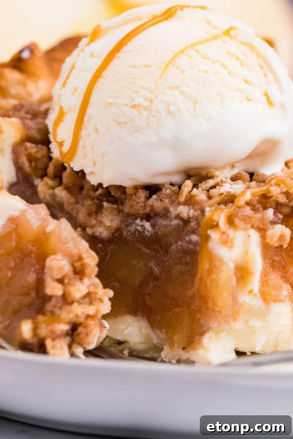 Apple Crumble Cheesecake Pie slice on plate with a bite taken out of it 