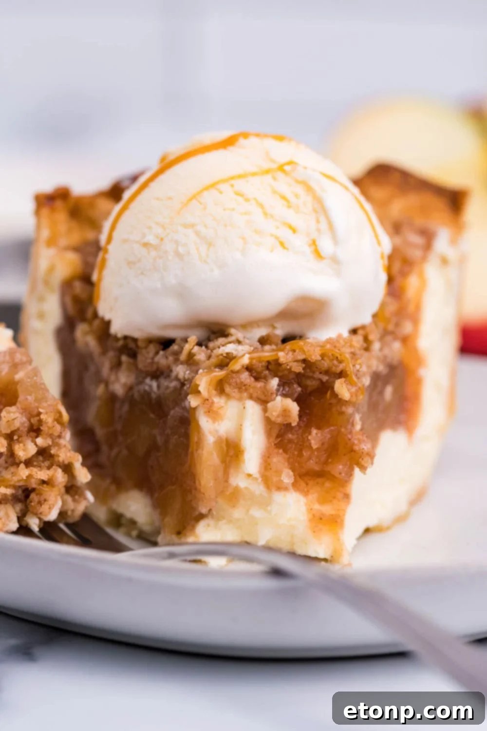 apple cinnamon cheesecake with some bites taken out of it