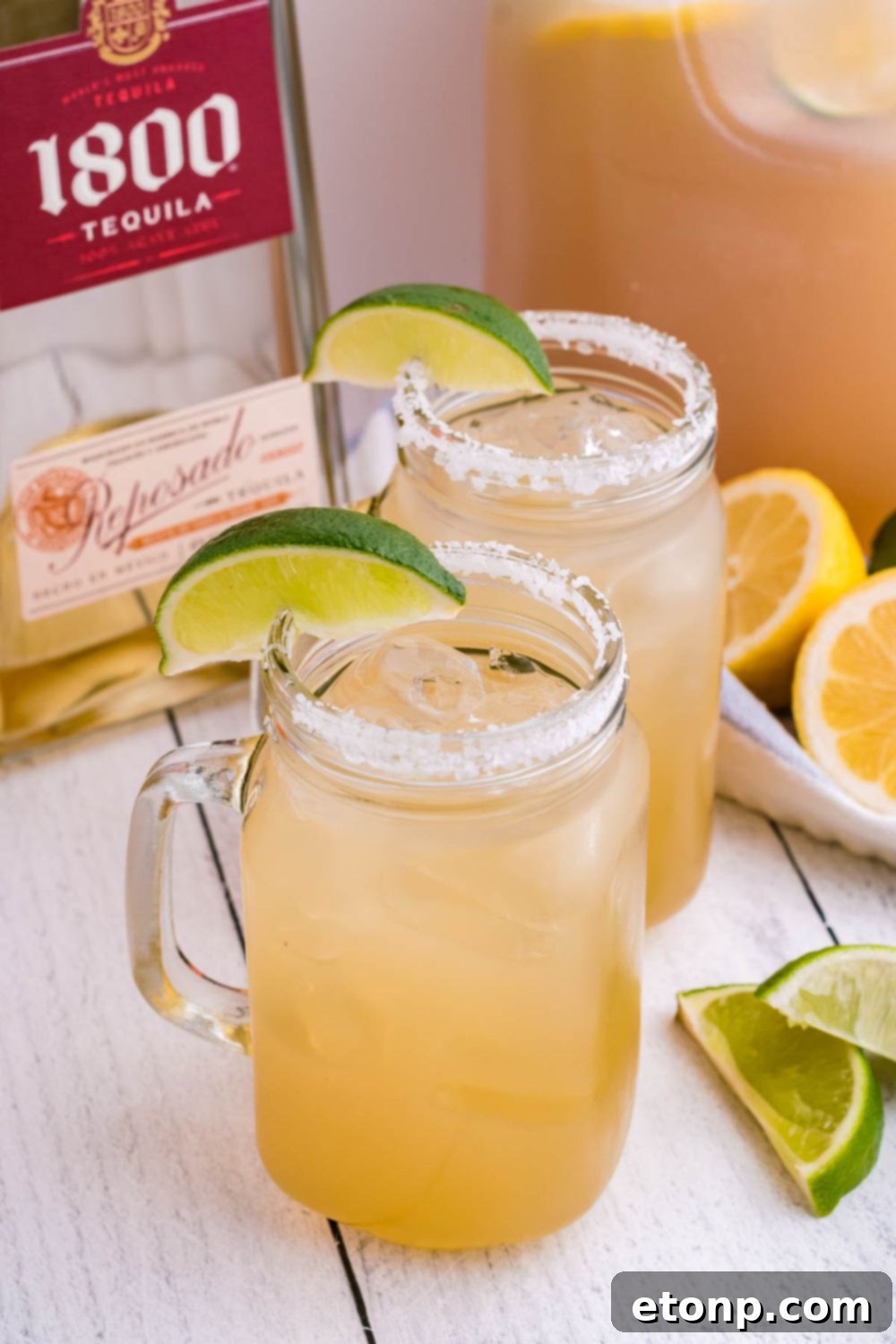 Close-up of a margarita being prepared, with a bottle of Triple Sec in the background, emphasizing the recipe's key ingredient