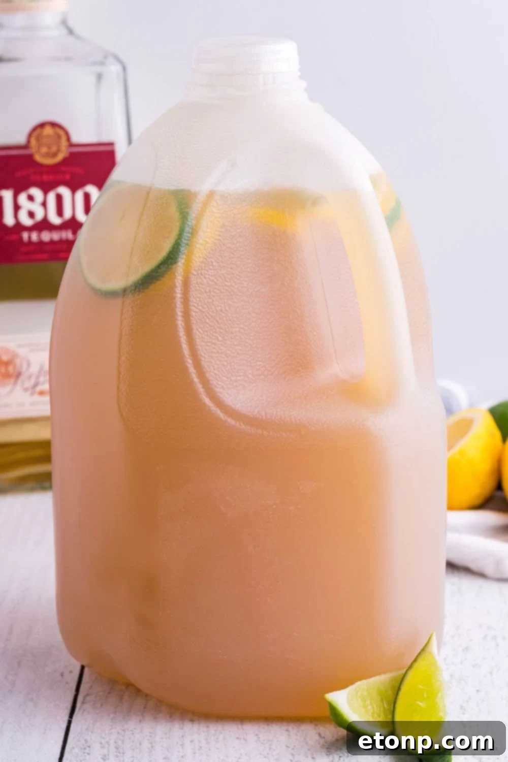 A gallon jug of margarita mix resting on a kitchen counter, ready for transport or serving