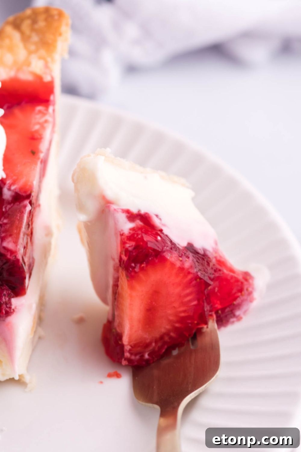 strawberry cheese pie with a fork full of a bite