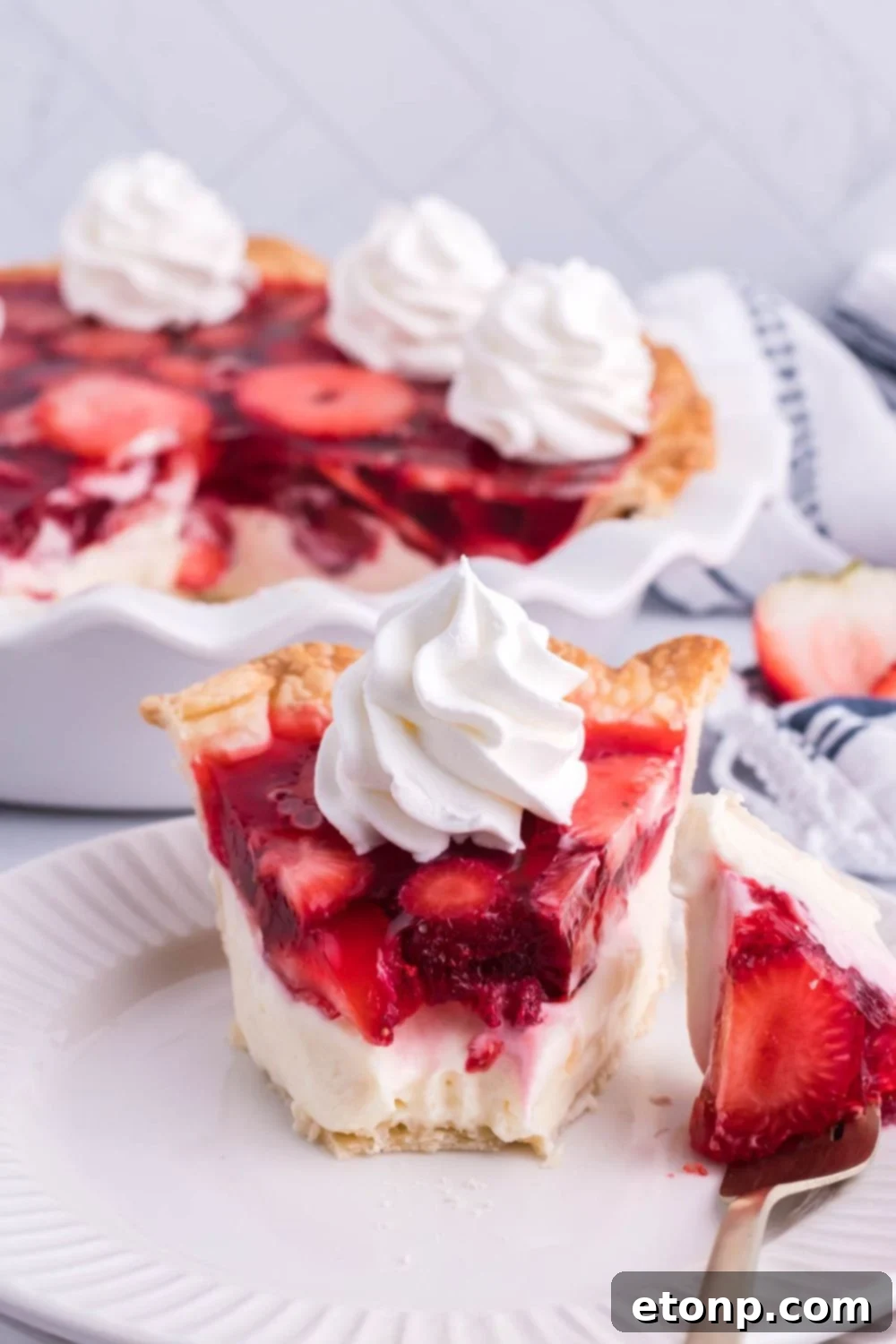 strawberry pie sliced on plate with a bite taken out of it