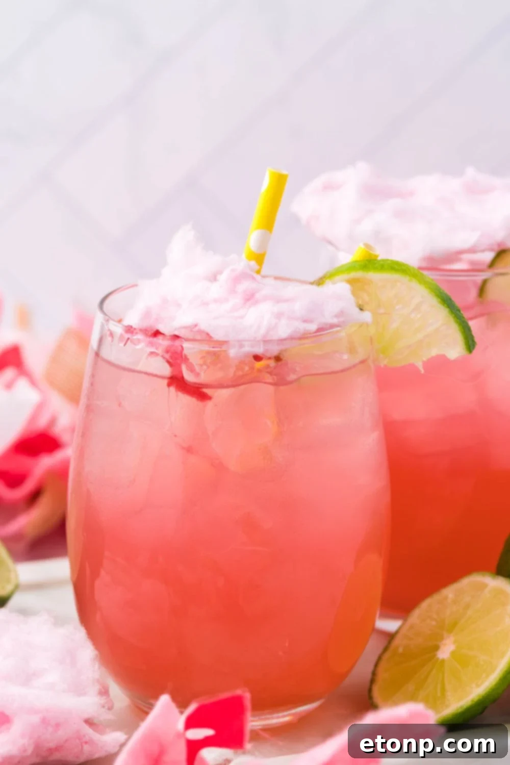 margaritas on table with straw and lime wedges for garnishment