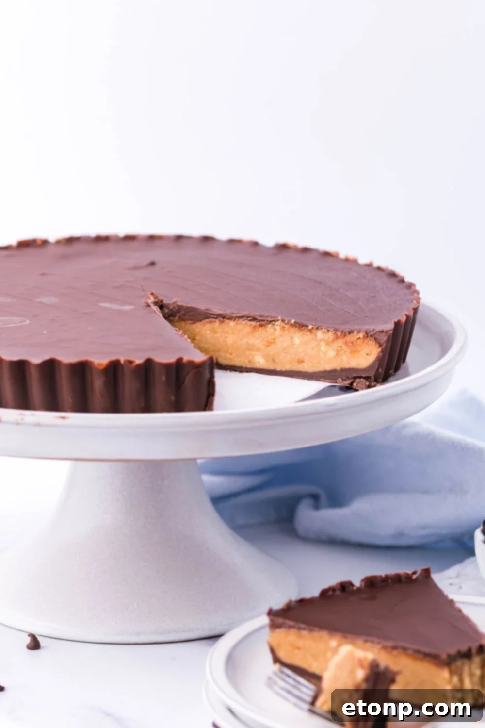 Giant Reese's Cup Pie on a tray and a single slice on a plate below it, highlighting its generous size