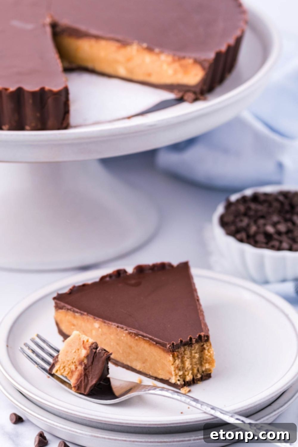 A slice of giant peanut butter cup pie resting on a wooden table, emphasizing its homemade appeal