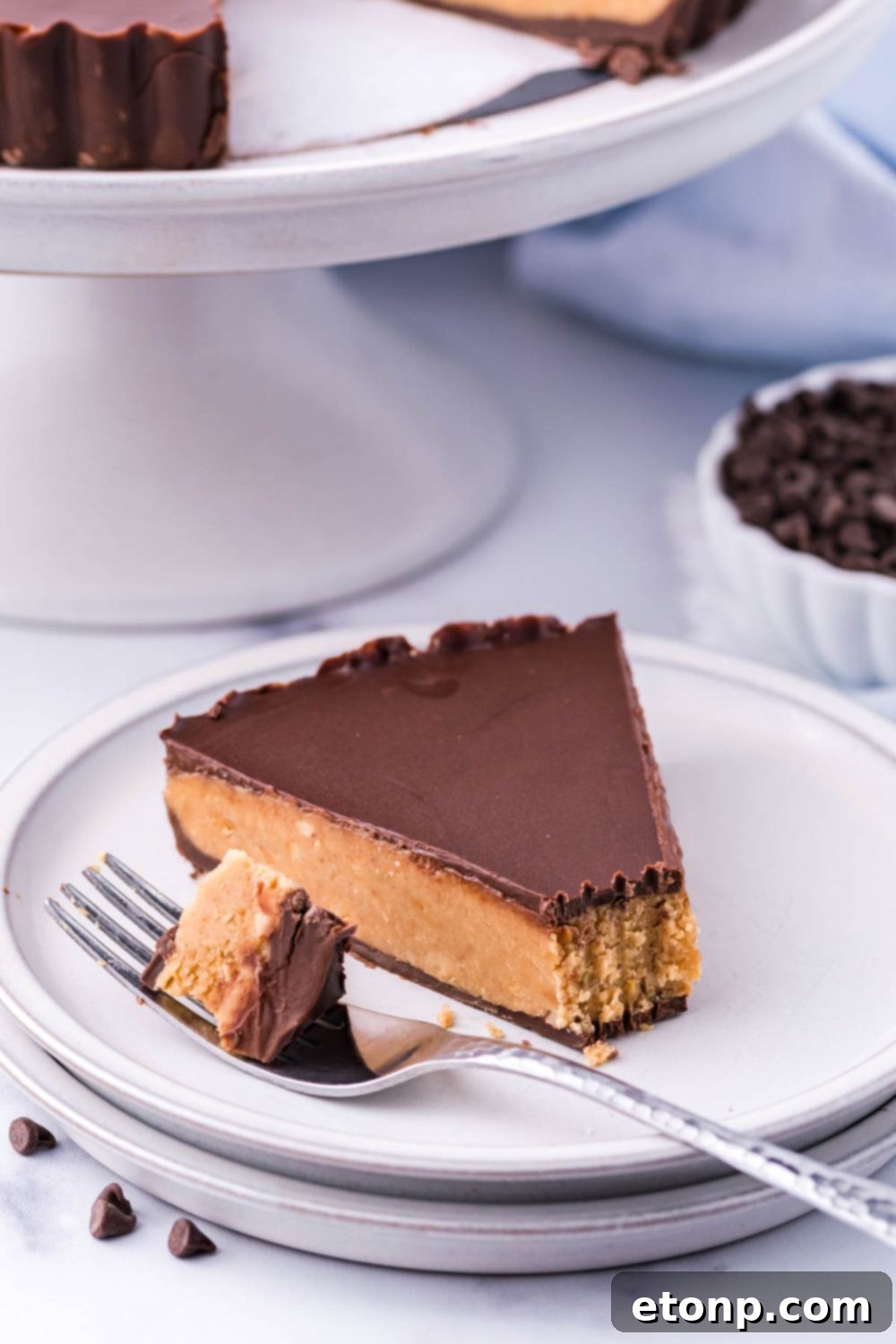 A delicious slice of Reese's pie on a plate with a fork, ready for a delectable bite