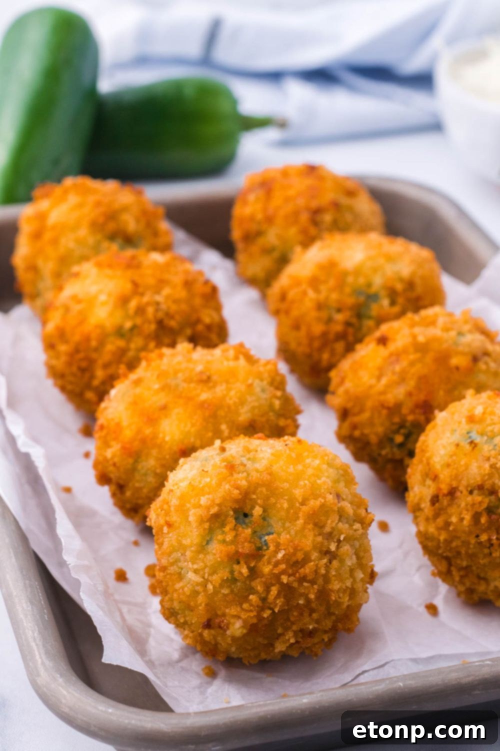 Crispy Jalapeno Cream Bombs 5 Jalapeno Popper Bites on a baking stray with parchment paper on it