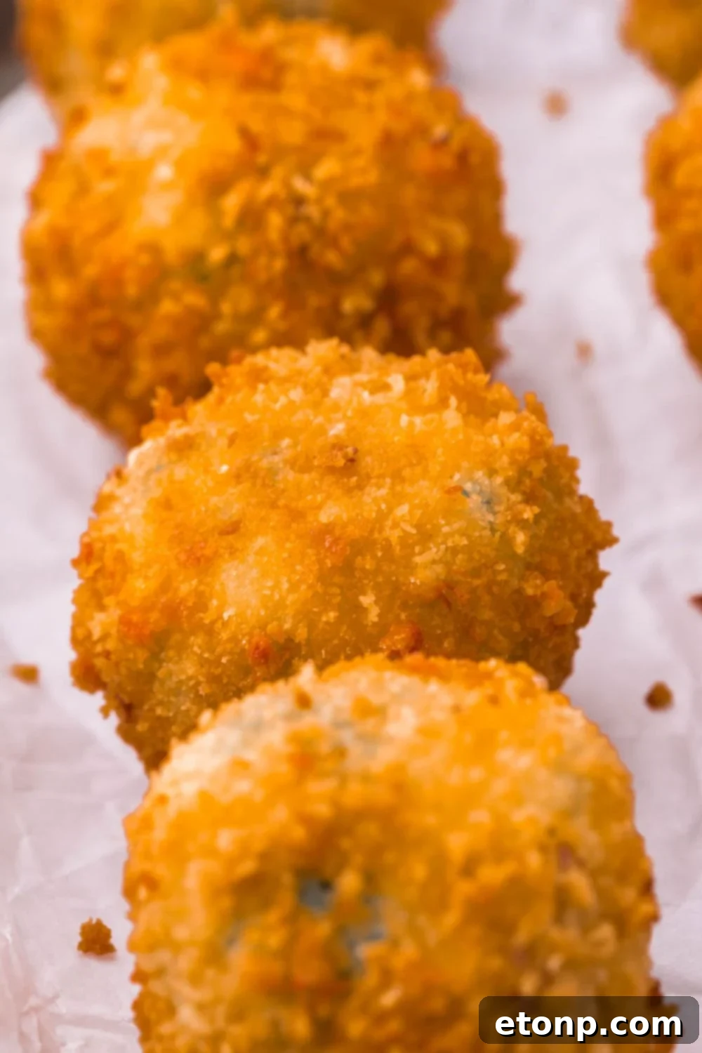 Crispy Jalapeno Cream Bombs 6 Jalapeno Popper Bites in a row on parchment paper