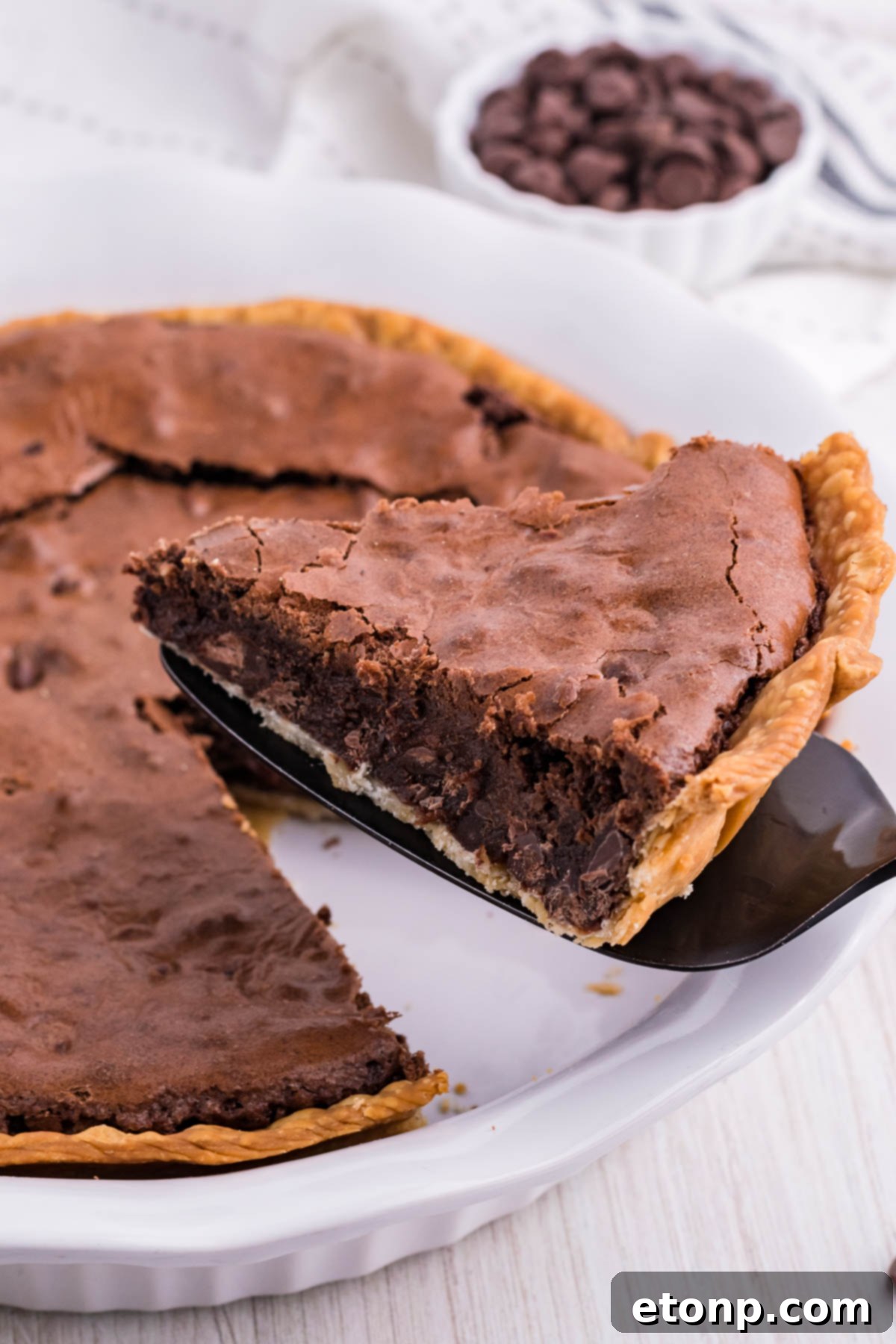 A close-up of a Fudge Brownie Pie, showing its rich, dark color and dense, inviting texture.
