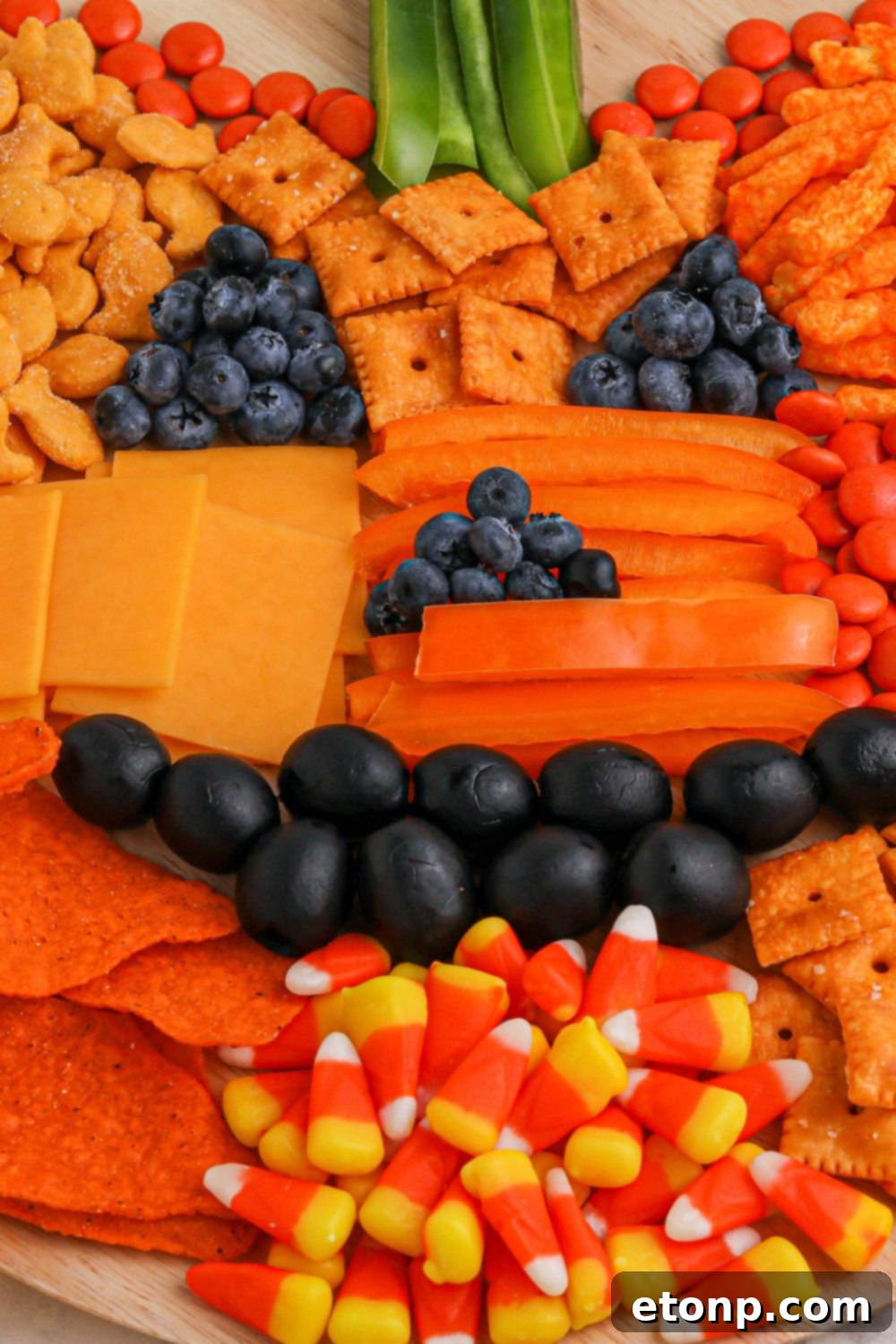 A beautifully arranged charcuterie board in the shape of a jack-o-lantern