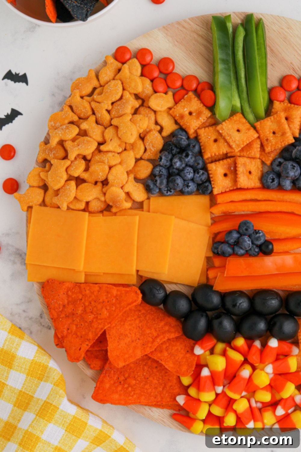 A vibrant Halloween snack board featuring a variety of themed treats and colors
