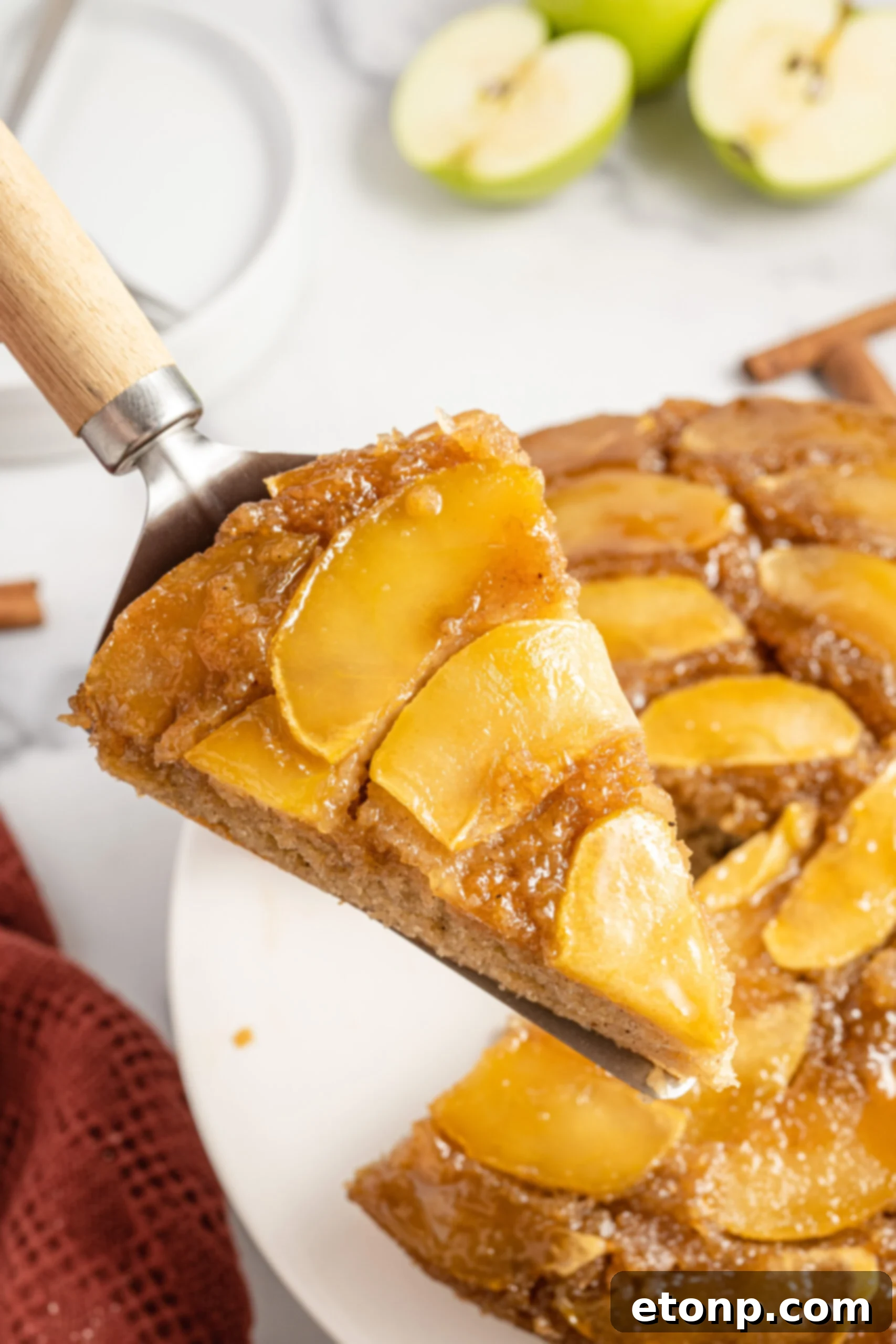 upside down apple cake on a spatula