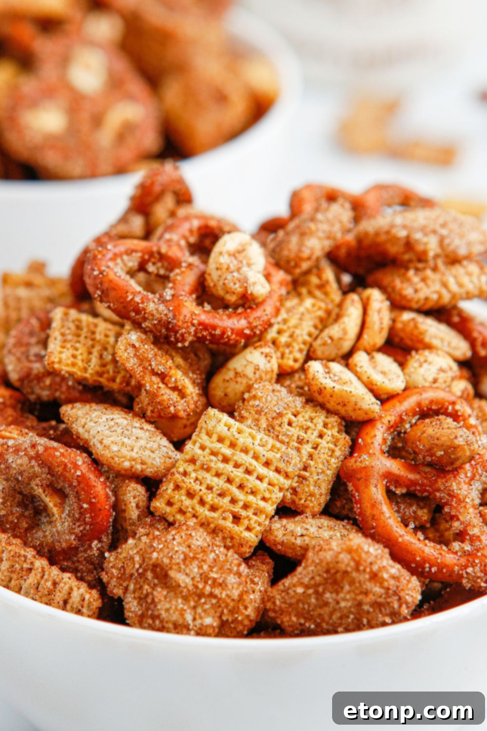 A close-up shot of the snack mix in a bowl, showcasing its crunchy texture and sweet cinnamon coating.