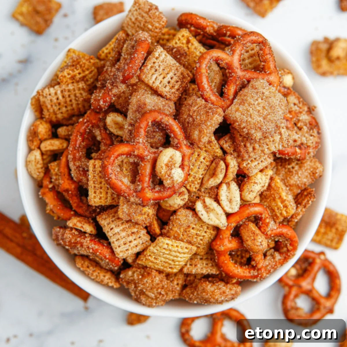 Close-up shot of Churro Chex Mix in a stylish bowl on a sleek marble counter, highlighting the sugary coating.