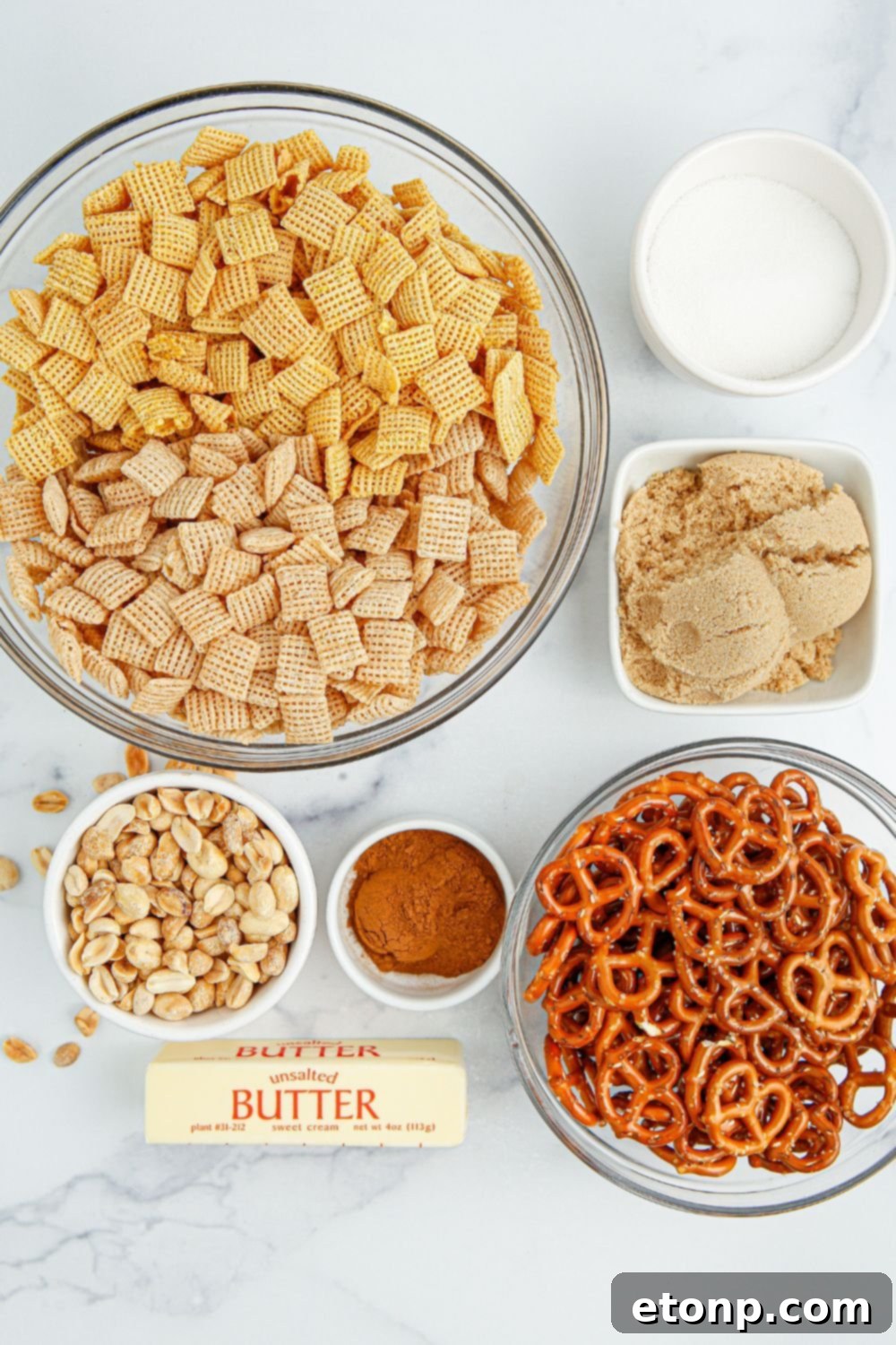 Various ingredients for Churro Chex Mix, meticulously arranged in clear glass bowls on a table, ready for mixing.