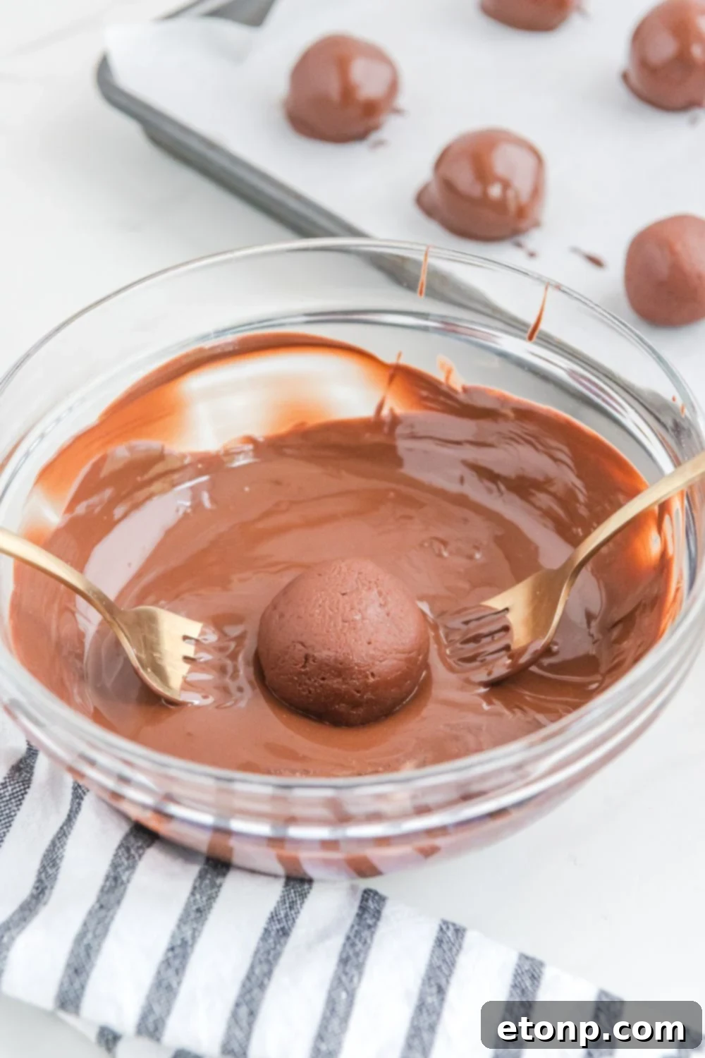 Fudgy Cherry Chocolate Bombs 12 dipping a brownie ball in melted chocolate