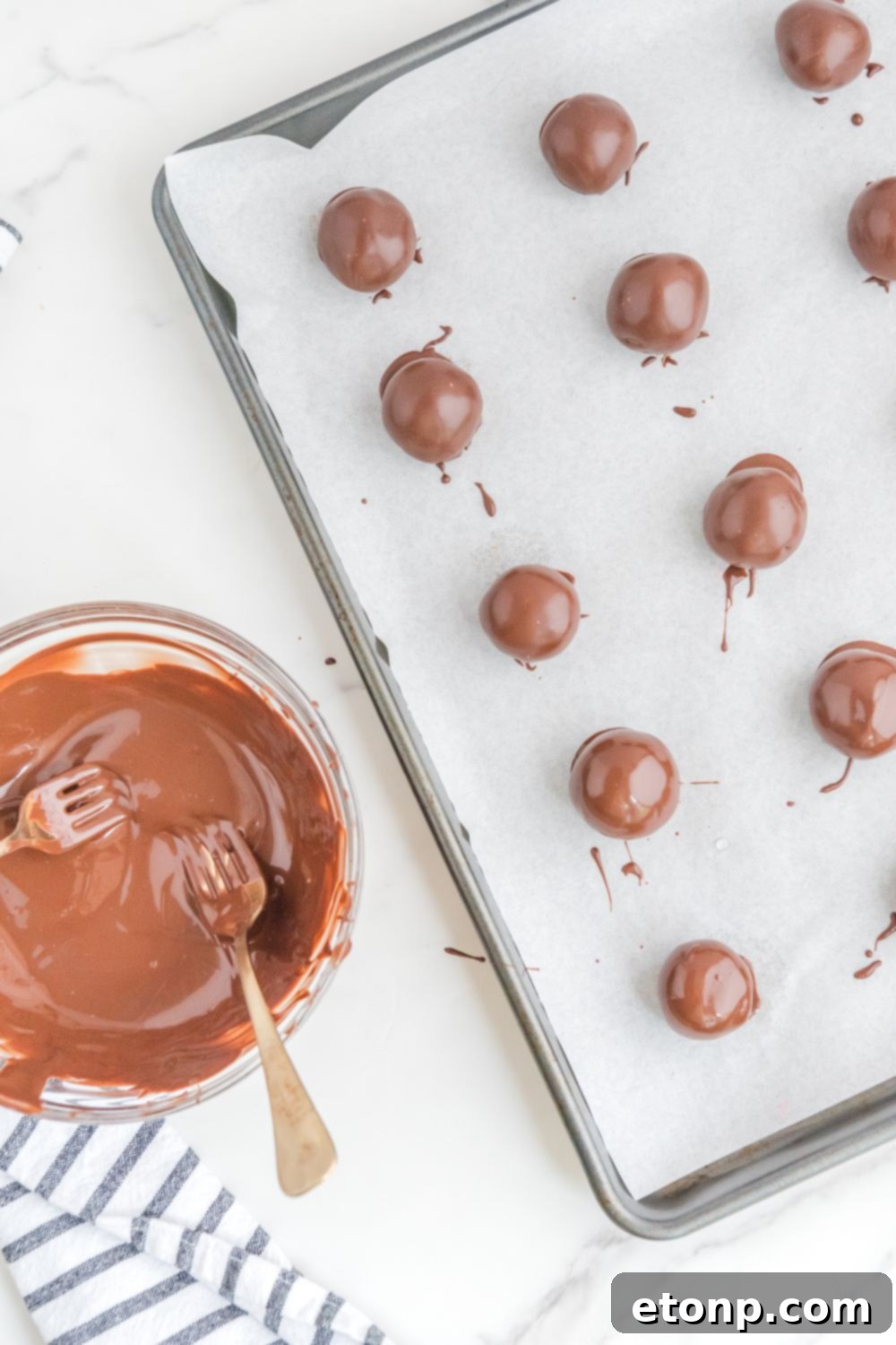 Fudgy Cherry Chocolate Bombs 14 brownie bites dipped in chocolate on a baking sheet
