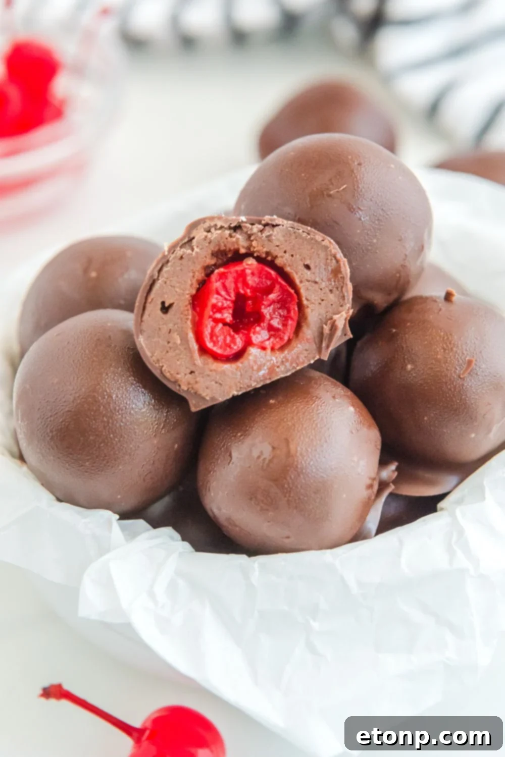Fudgy Cherry Chocolate Bombs 5 brownie bites in a bowl on table with cherries around it