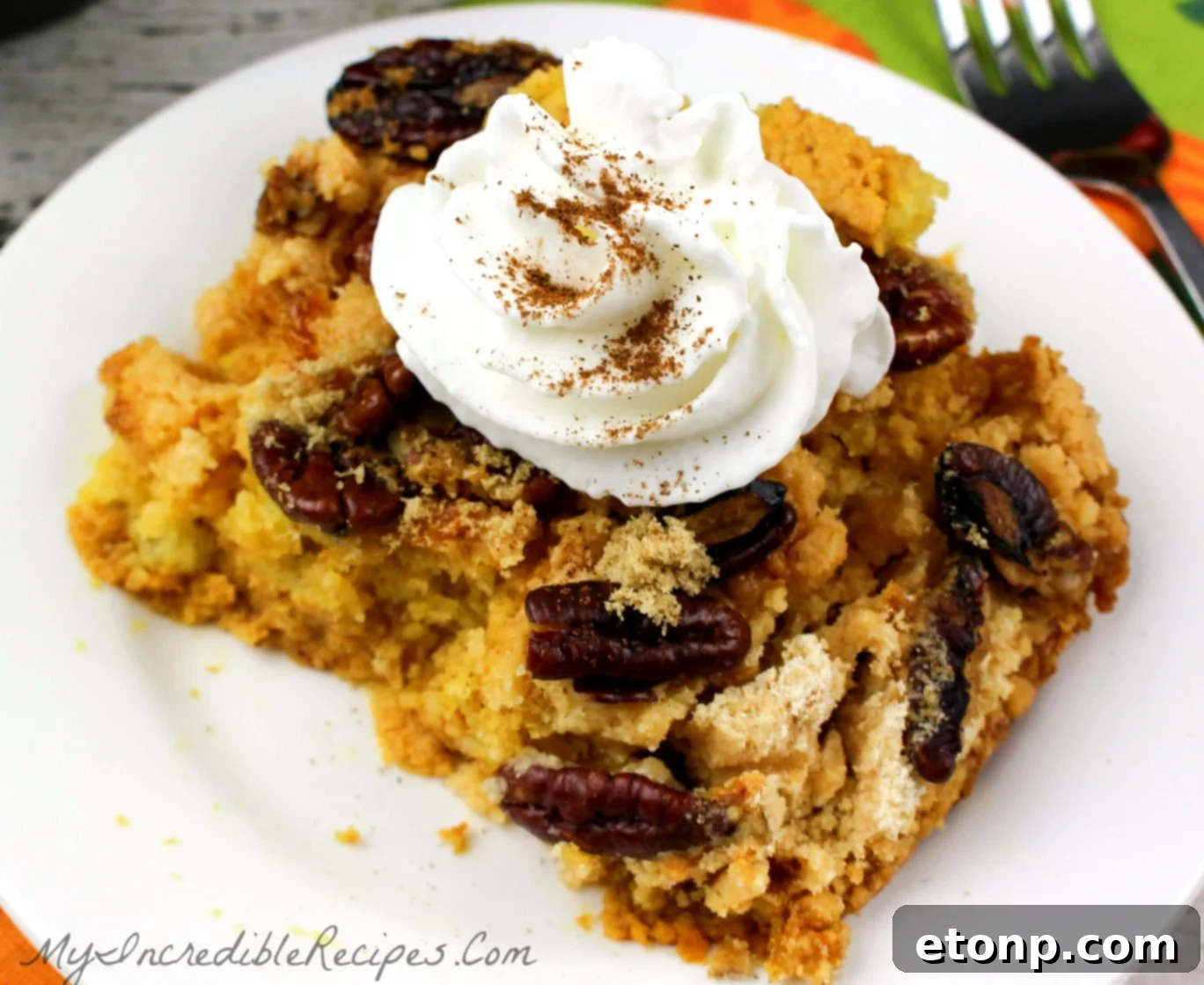 Simply Divine Pumpkin Pecan Dump Cake 17 Pumpkin Pecan Dump Cake placed on an autumn-themed table setting, surrounded by fall leaves and decorative elements.