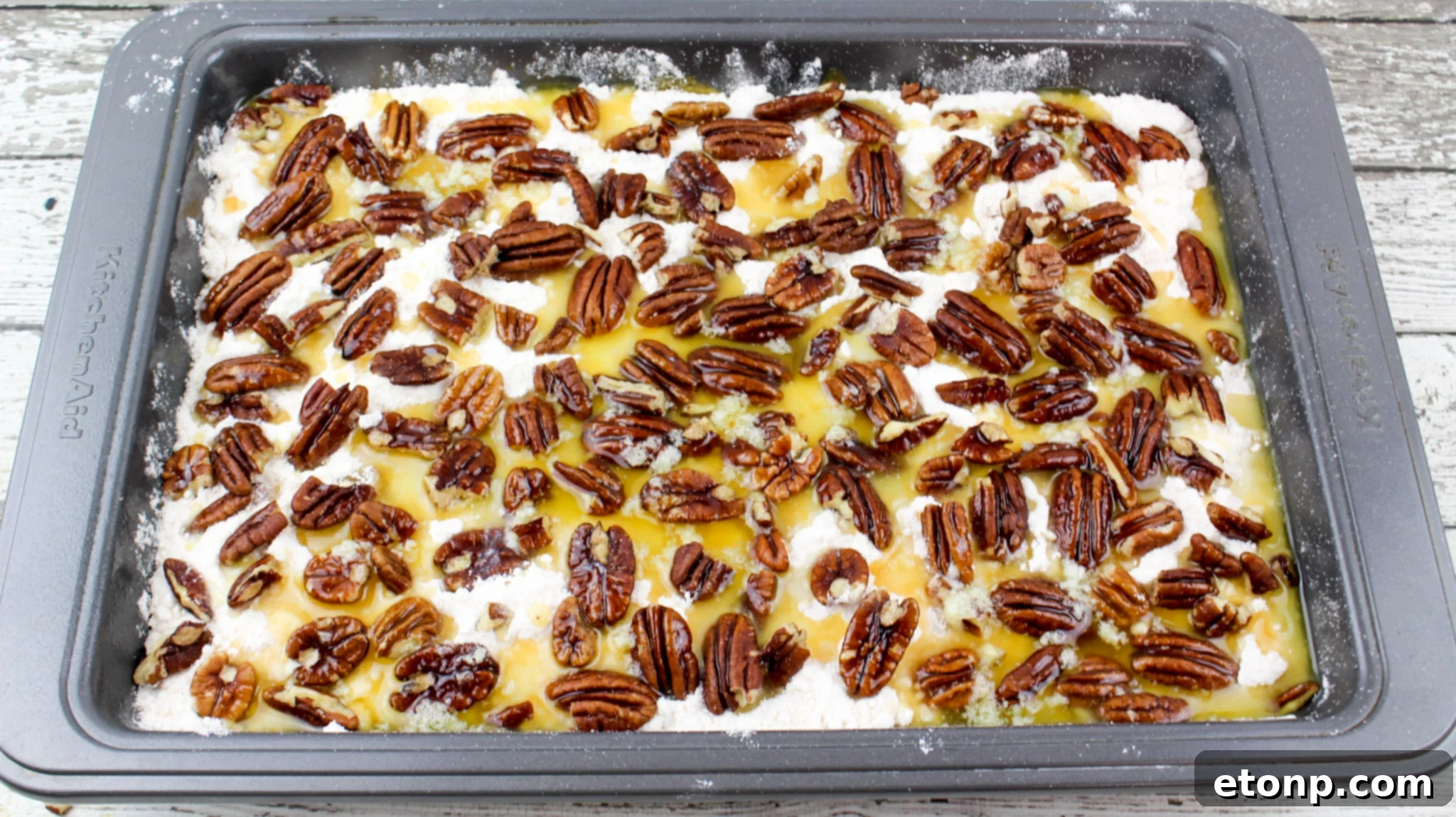 Simply Divine Pumpkin Pecan Dump Cake 10 The cake cooling in its pan, showing the rich, caramelized pecan crust and its appealing golden color.