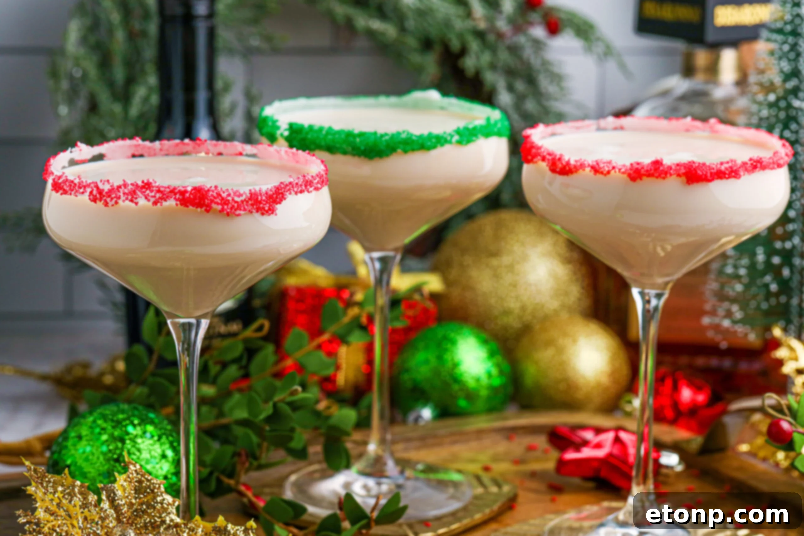 Sugar Cookie Cocktails in glasses with red and green sugar rims on a wooden table 