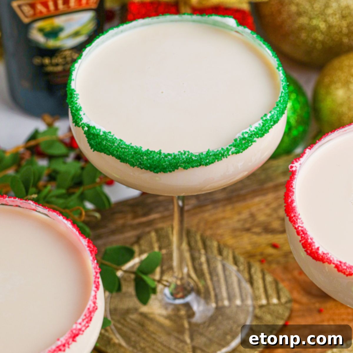 Sugar Cookie Cocktails in glasses with red and green sugar rims on a wooden table 