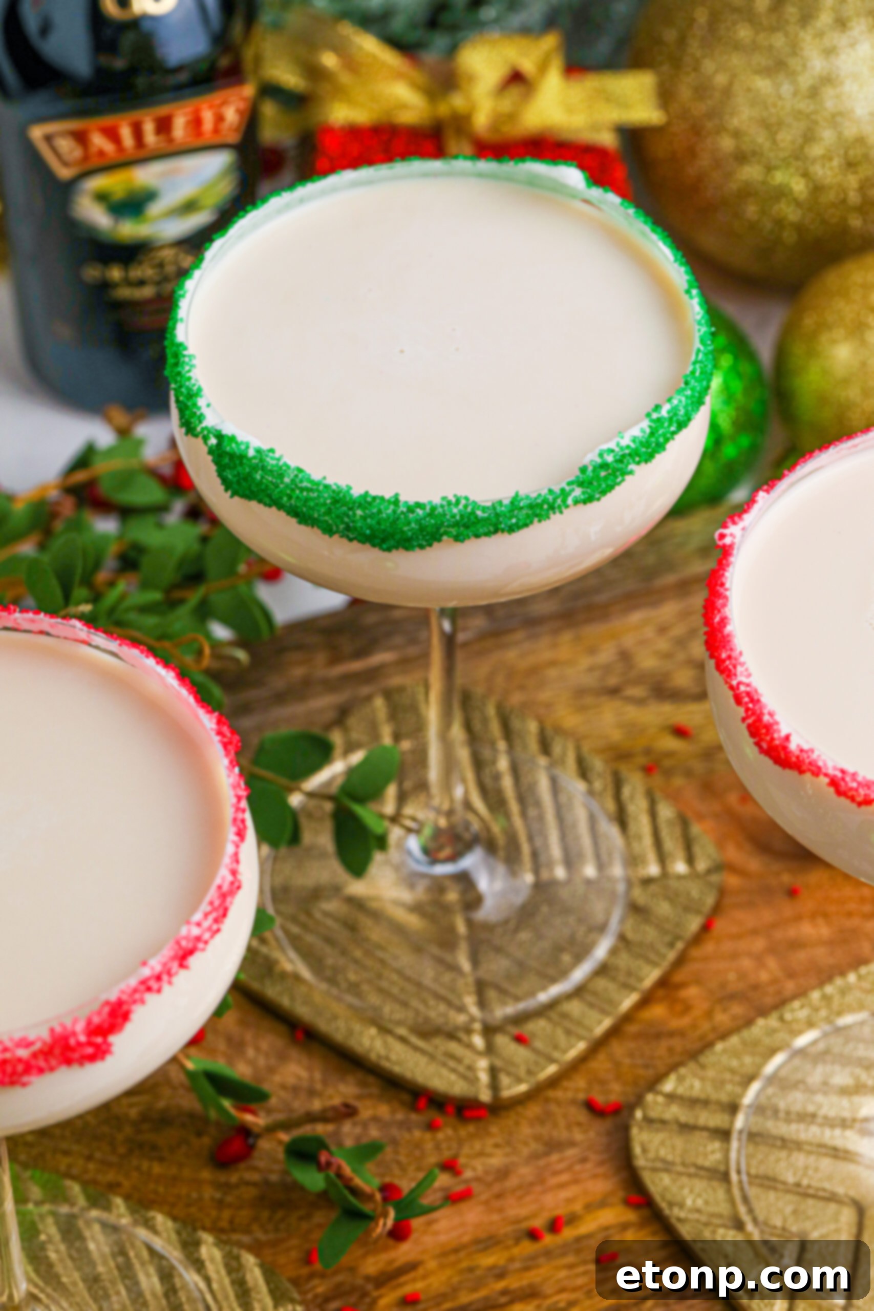 Sugar Cookie Cocktails in glasses with red and green sugar rims on a wooden table 