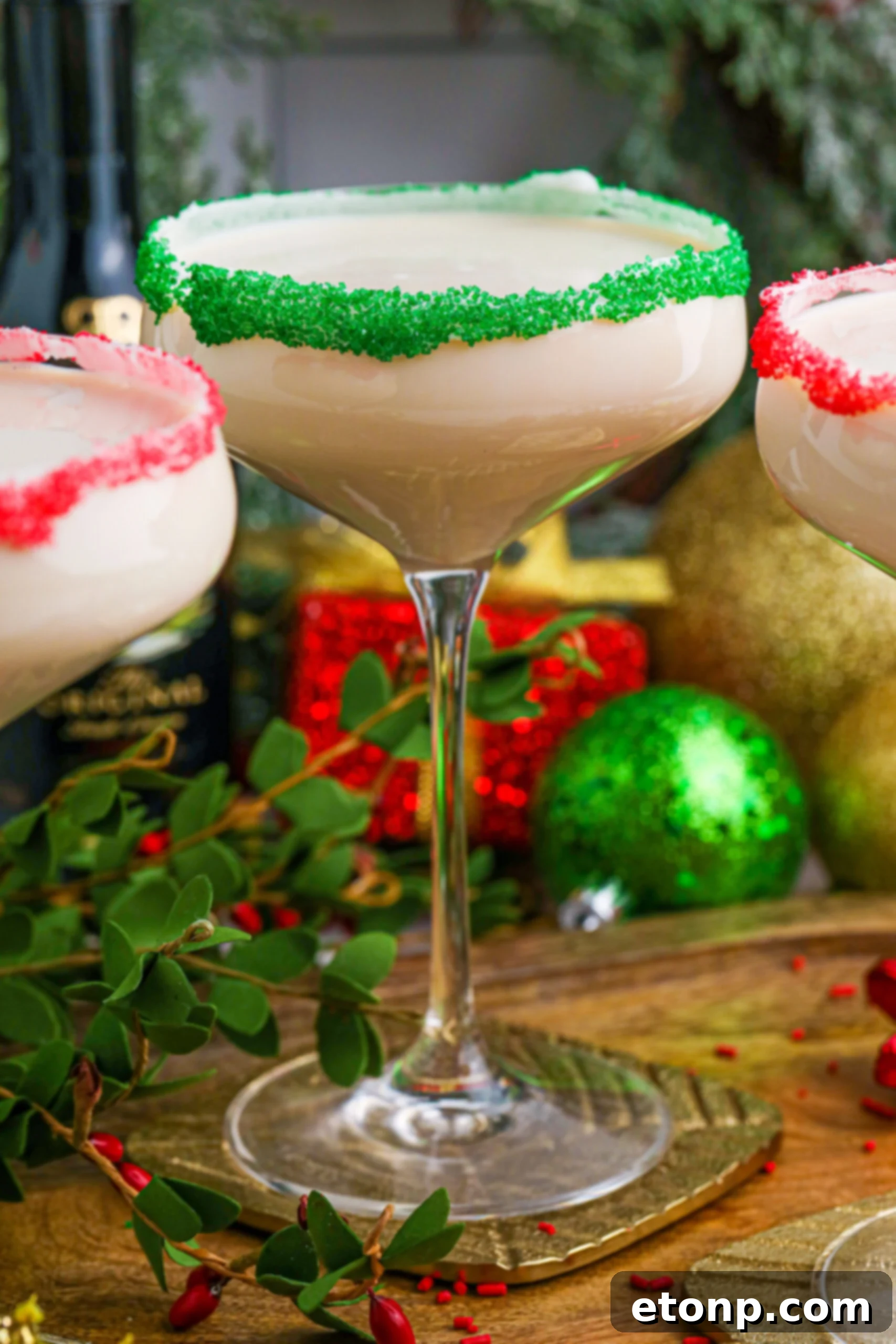 Sugar Cookie Cocktails in glasses with red and green sugar rims on a wooden table 