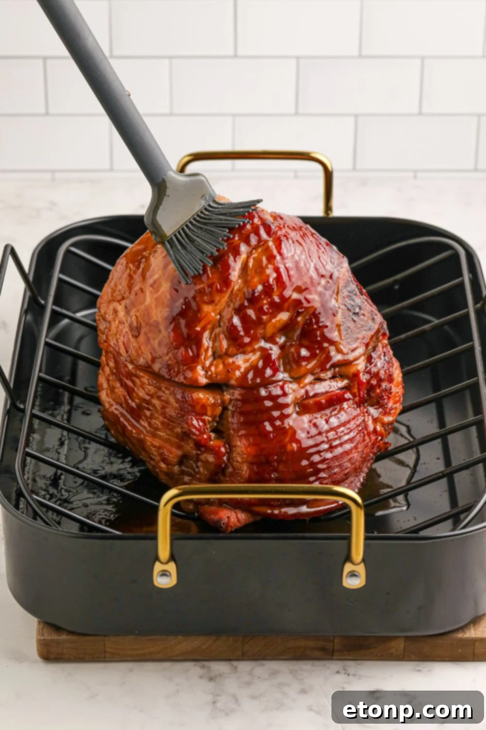 Dr. Pepper Glazed Ham 7 brushing ham with a glaze on roasting pan