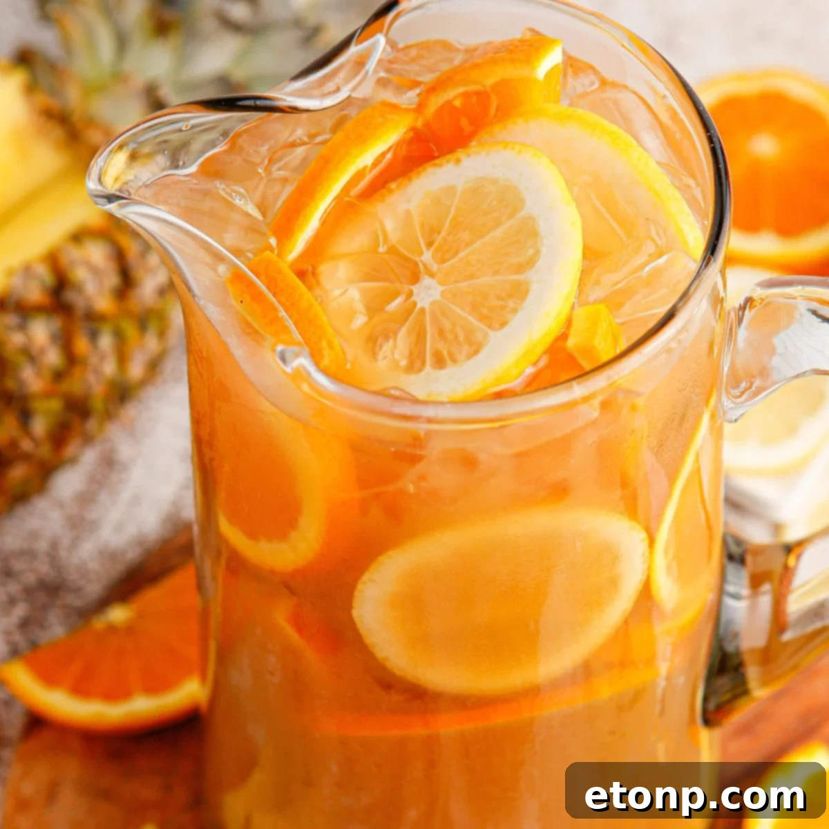 Large pitcher of Touchdown Tea on a table with fresh fruit slices