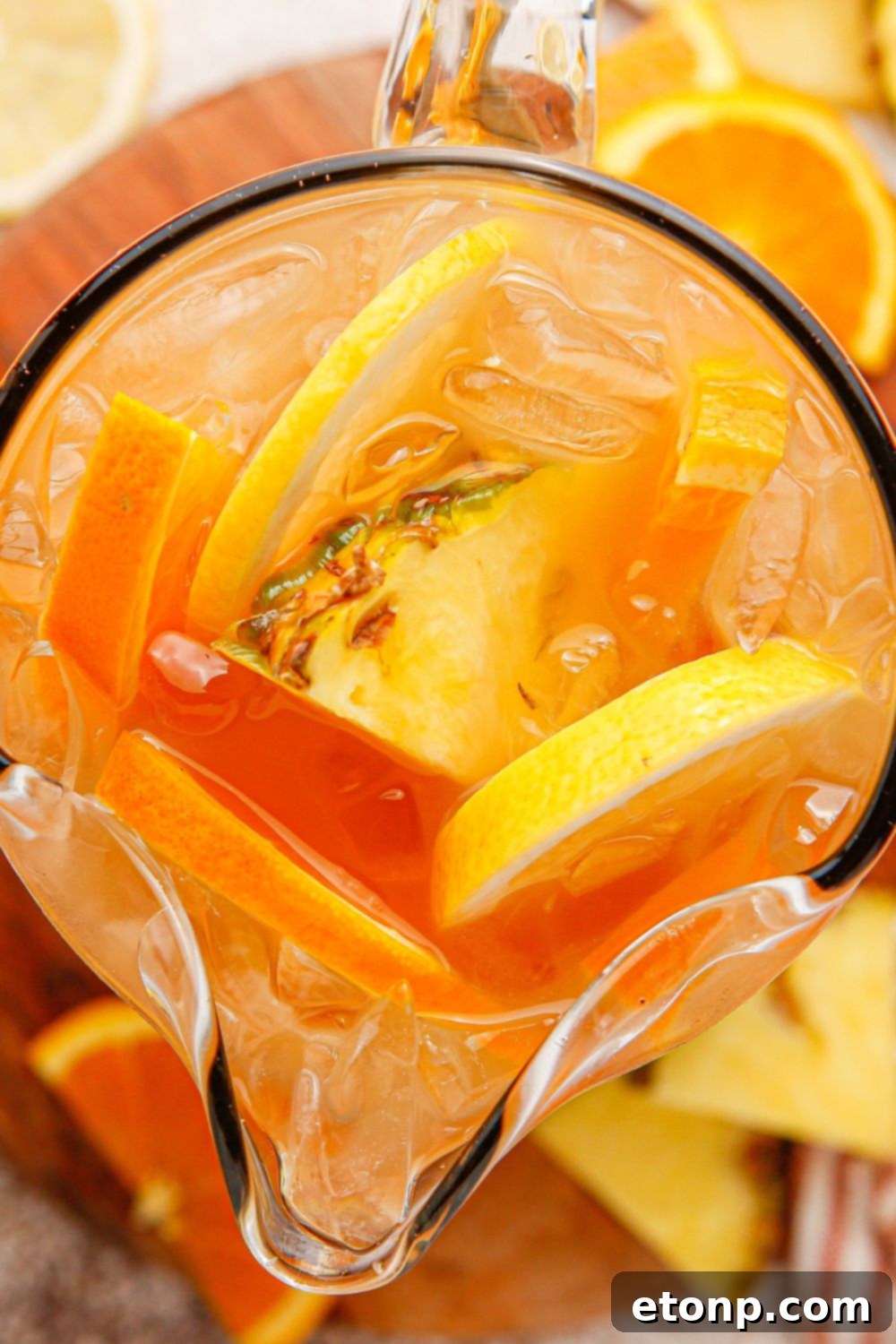 Sweet tea bourbon in a glass serving container with sliced fruit