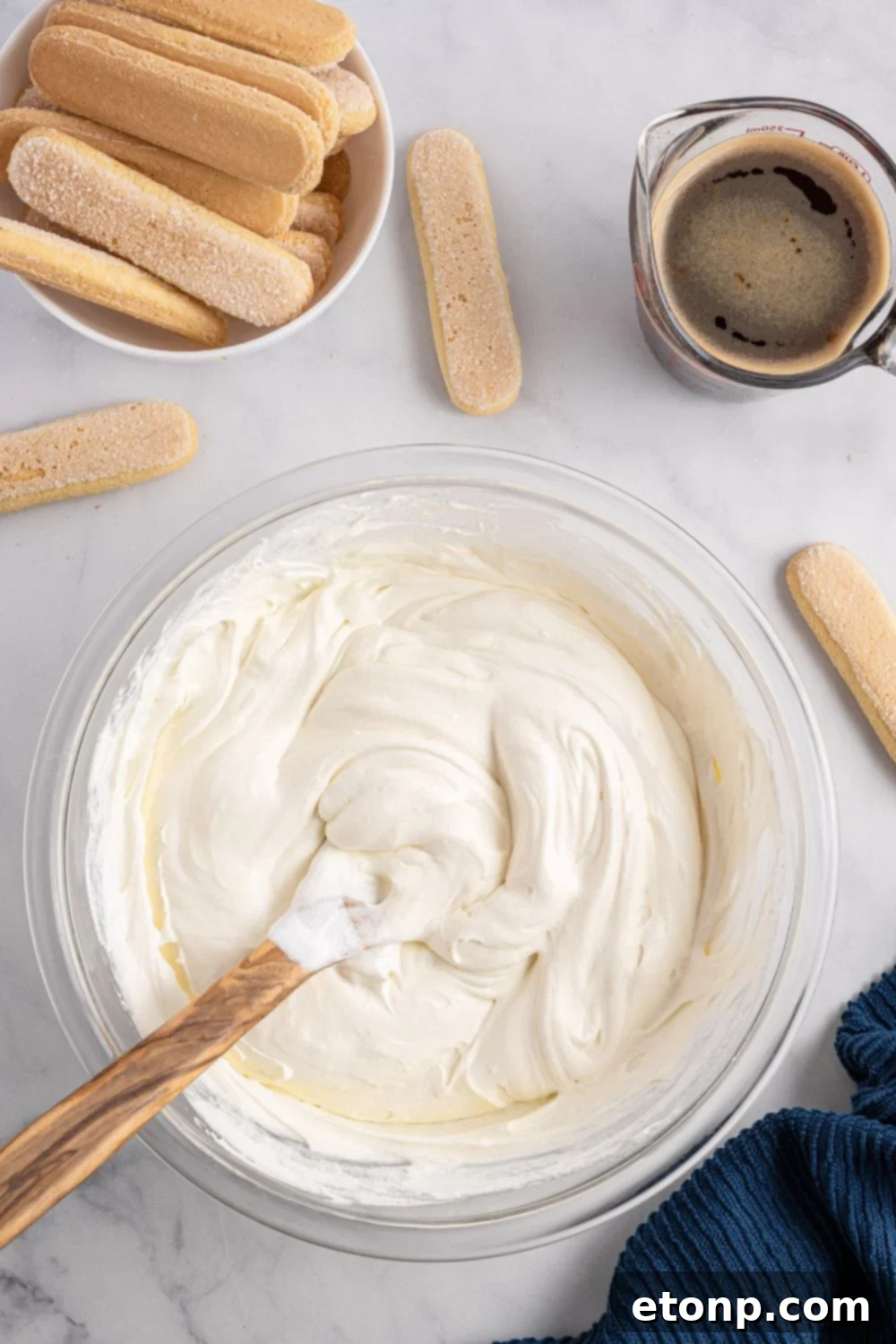 A close-up shot of the creamy mascarpone mixture being expertly mixed in a bowl, showcasing its smooth and inviting texture.