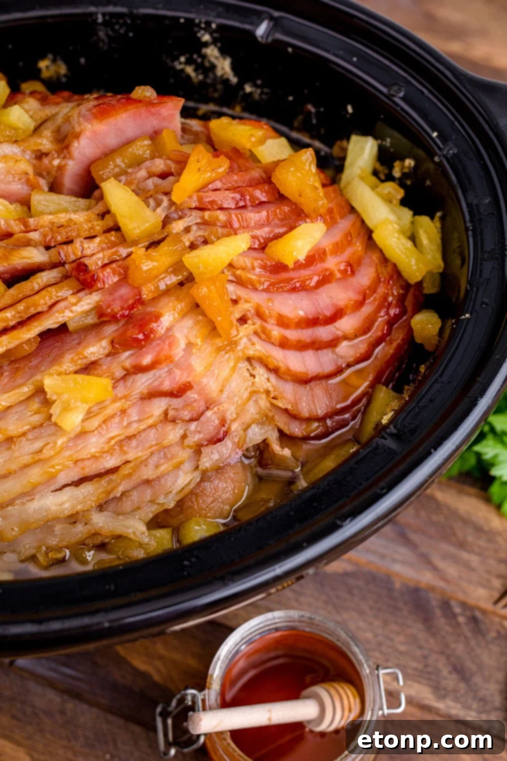 ham in crockpot with a honey jar on the side