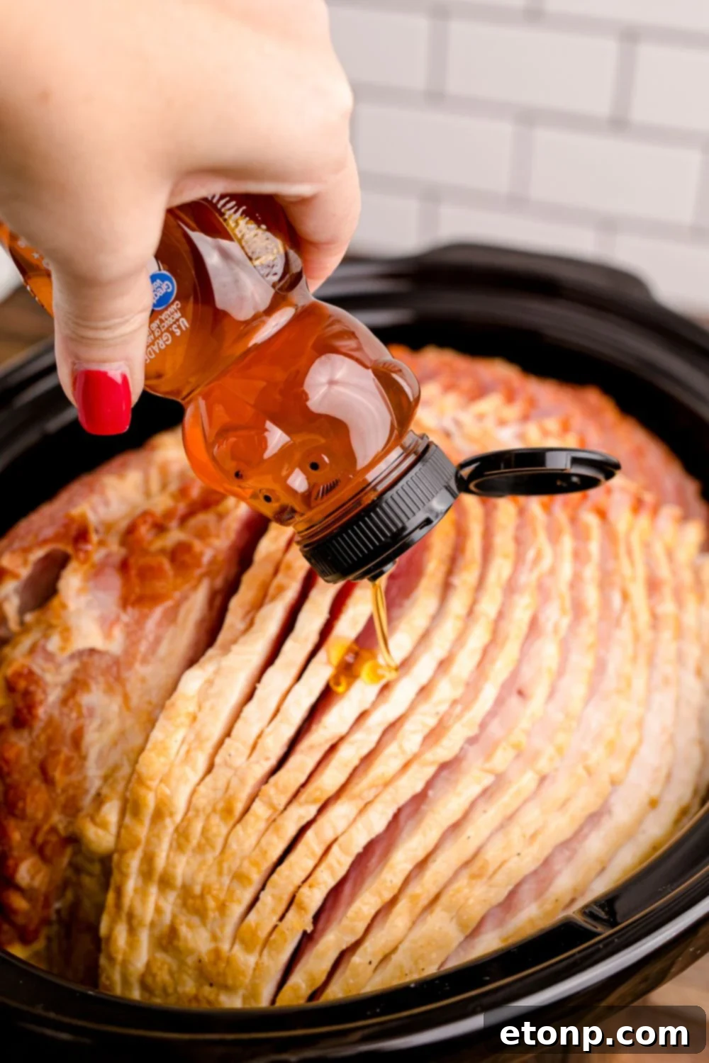 honey drizzling over a ham in slow cooker 