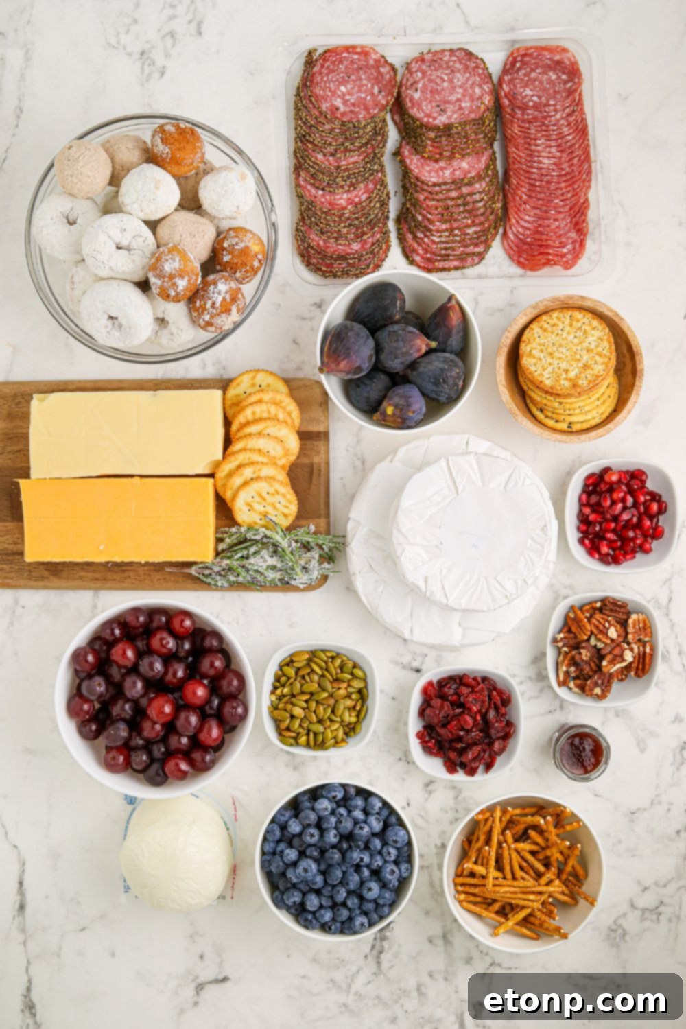 Whimsical Snowman Snack Board 4 A selection of ingredients laid out on a table, ready for assembling the Snowman Charcuterie Board.