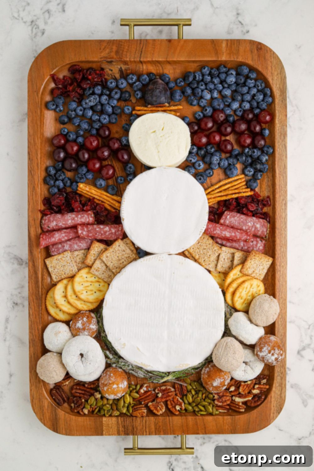 Whimsical Snowman Snack Board 7 Adding facial features and details to the cheese snowman charcuterie board.