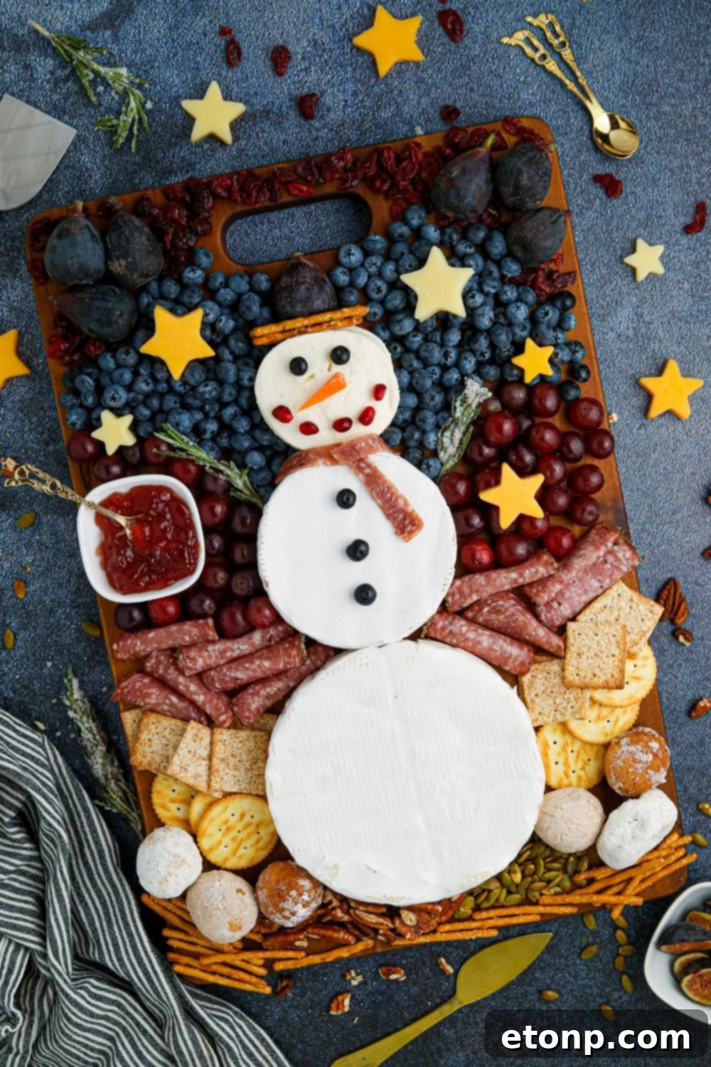 Whimsical Snowman Snack Board 9 A finished snowman snack tray on a wooden table, adorned with festive treats.