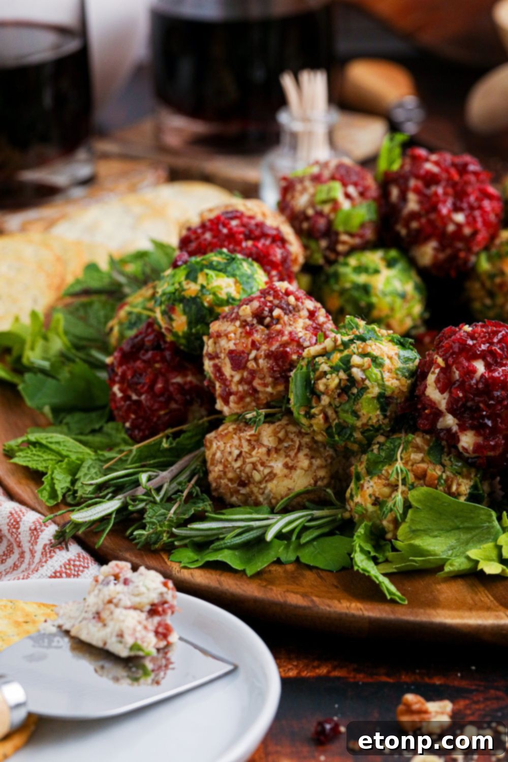 Cheese Ball Wreath on table with some cheeseballs placed on a plate 