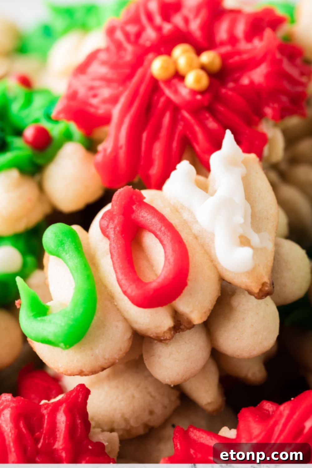 joy shaped cookie stacked on top of other cookies on tray