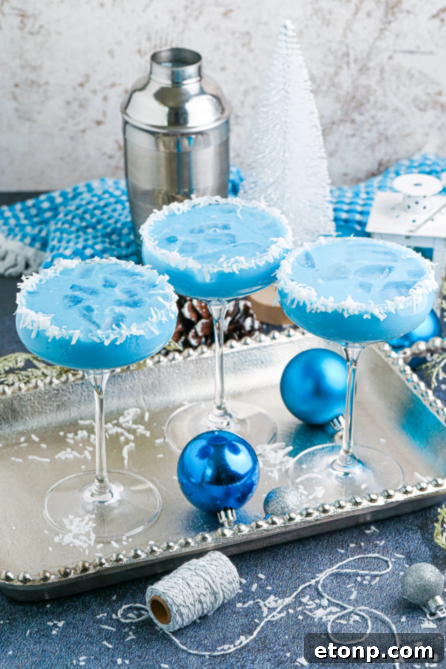 3 glasses of the blue Christmas cocktail on a silver platter
