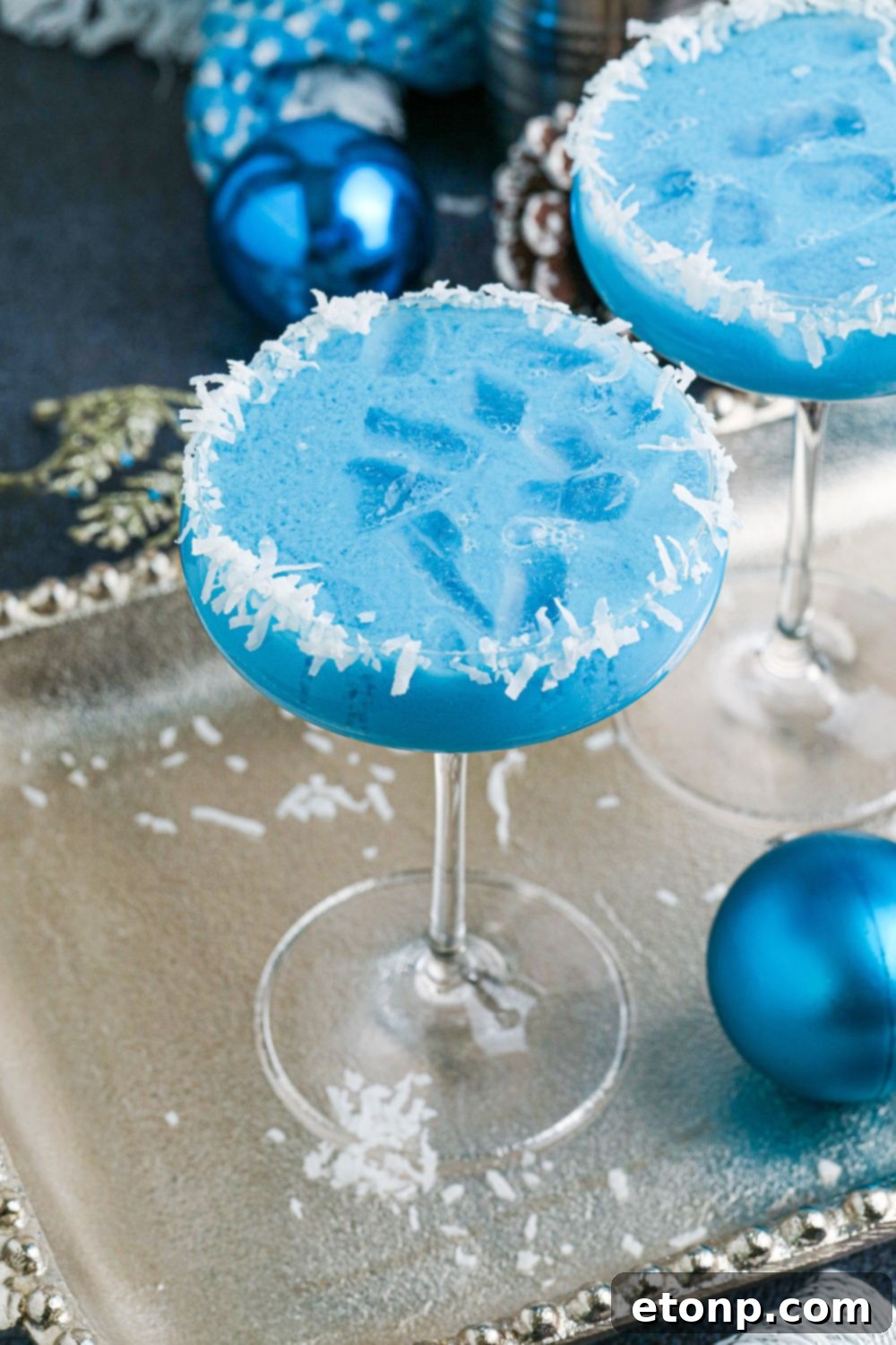 Christmas cocktails on silver platter with blue Christmas balls around it