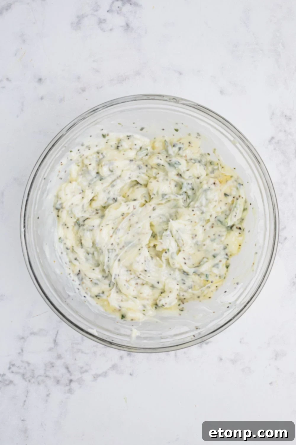 herb butter mixed together in a glass bowl on table