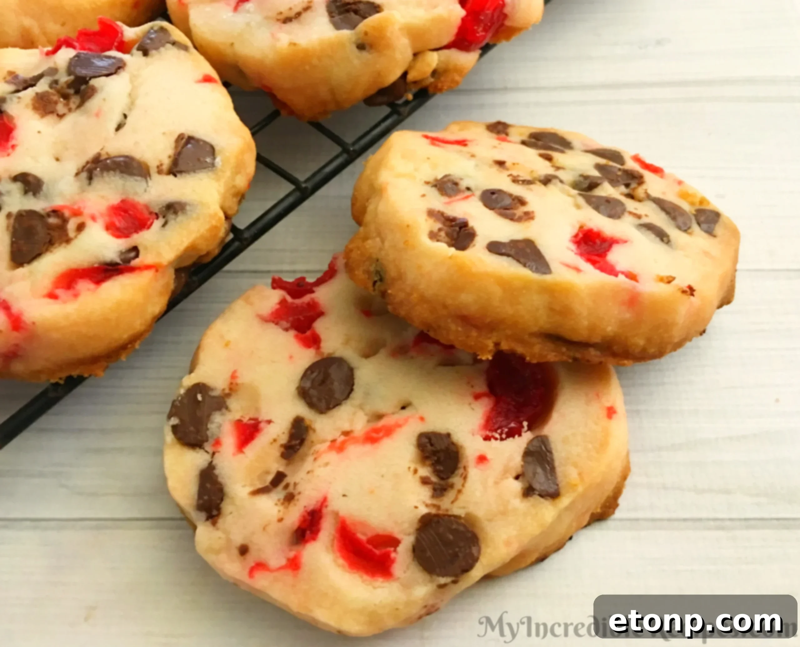 Buttery Maraschino Cherry Christmas Shortbread 2 Freshly baked Maraschino Cherry Shortbread Christmas Cookies on a cooling rack, ready to be enjoyed.