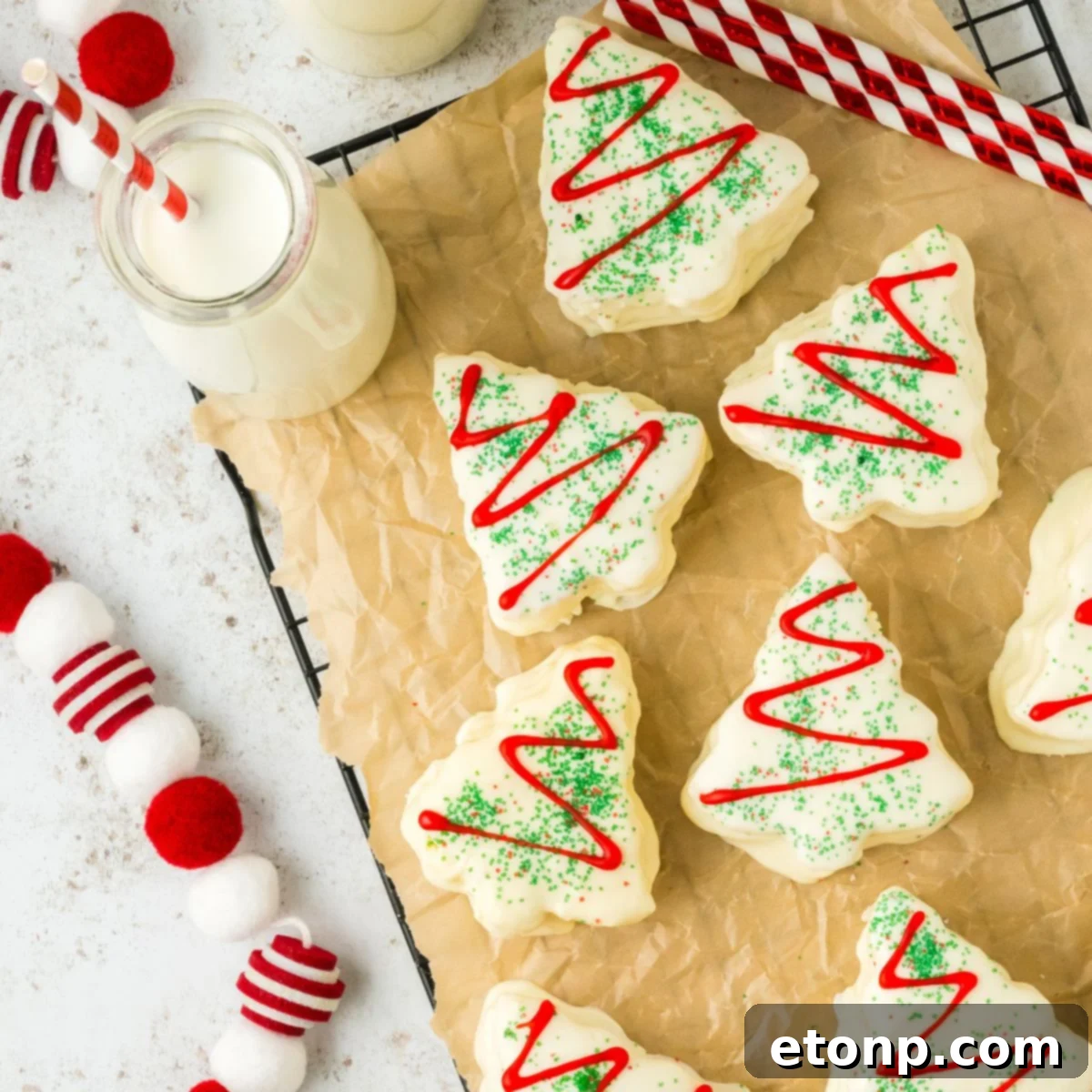 Christmas tree cakes on a table with milk and Christmas decorations around it