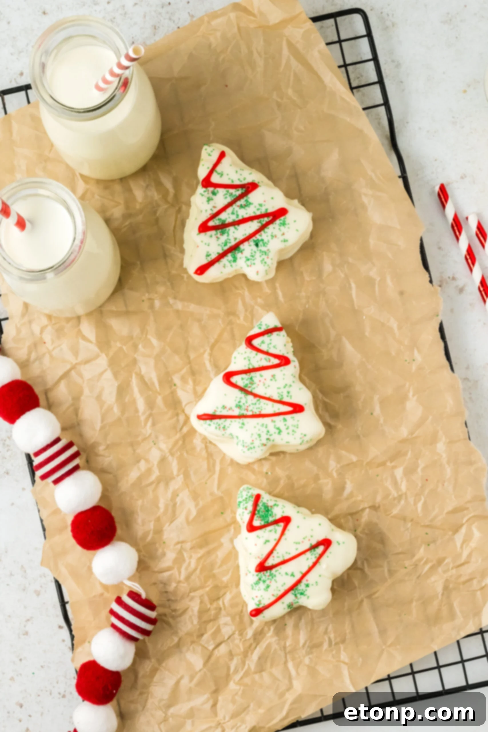 little debbie cakes on a parchment paper tray with glasses of milk around it
