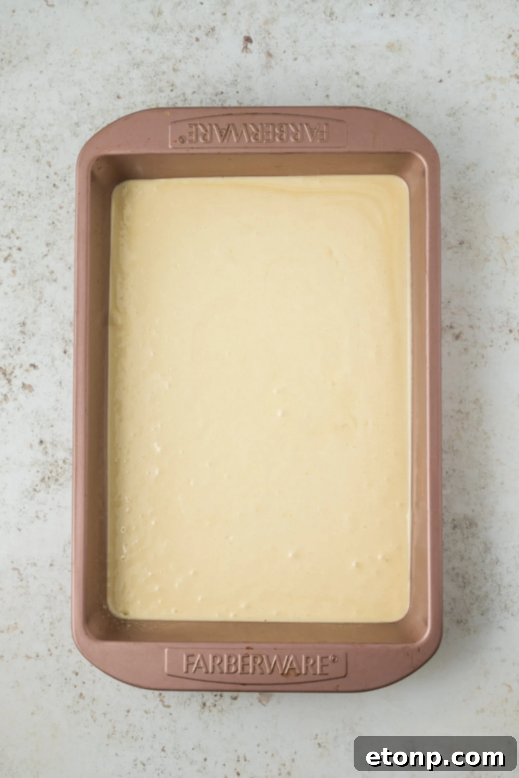raw cake batter in a baking pan