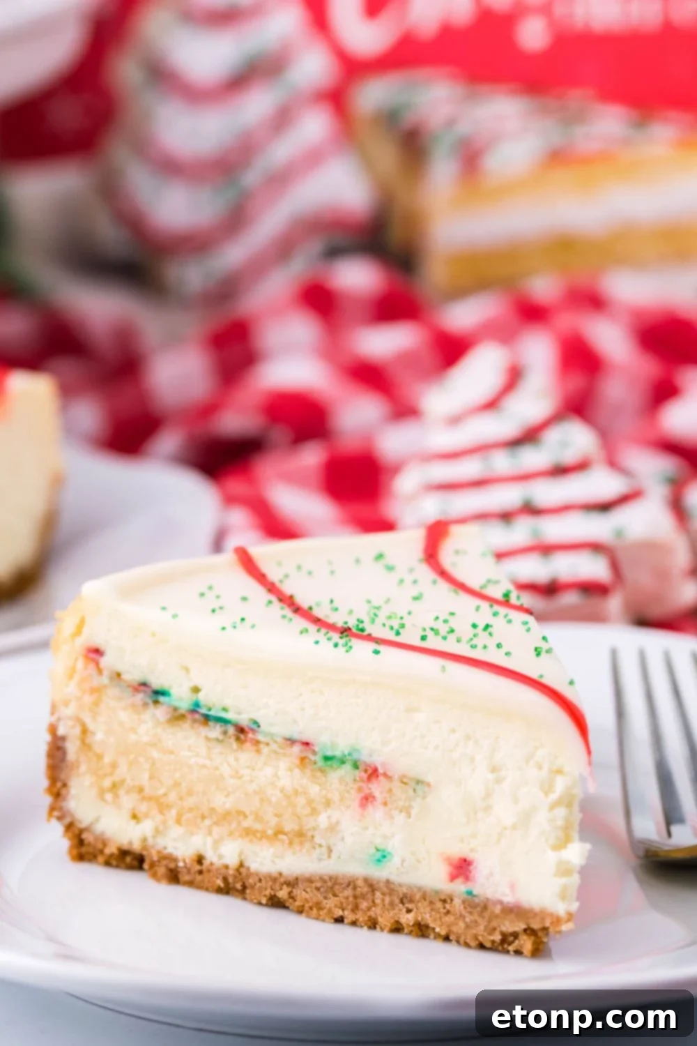 A delightful slice of Little Debbie Christmas Tree flavored cheesecake on a plate, accompanied by a fork, ready to be savored.