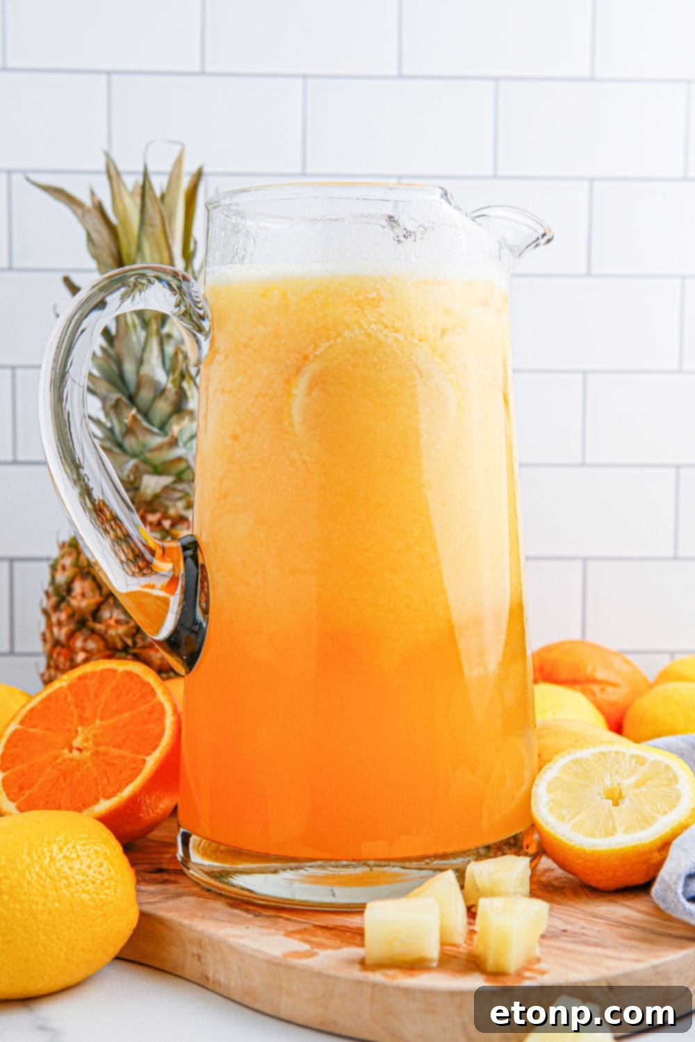 mango pineapple punch in a glass pitcher