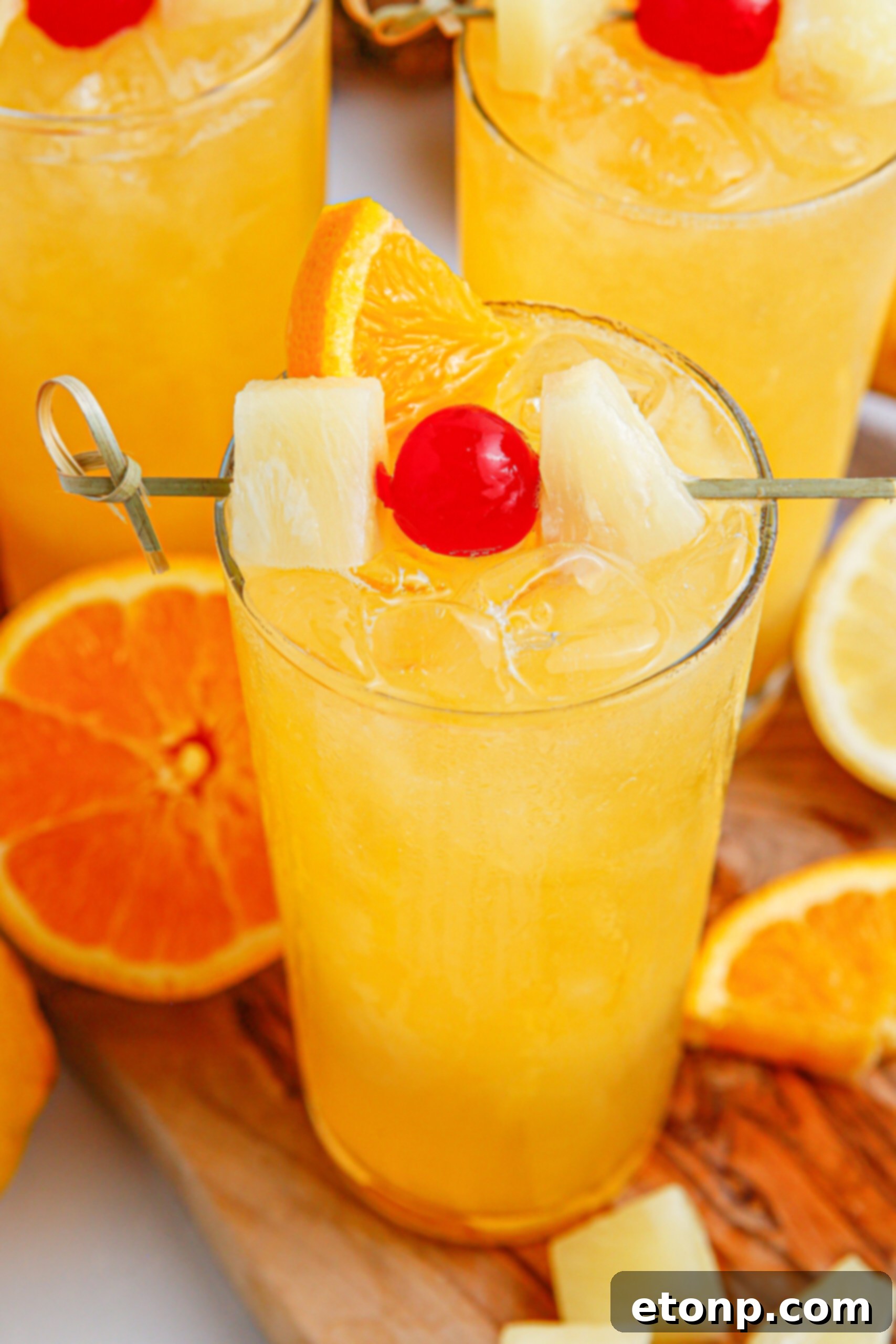 glass of punch on table with orange and cherry on top