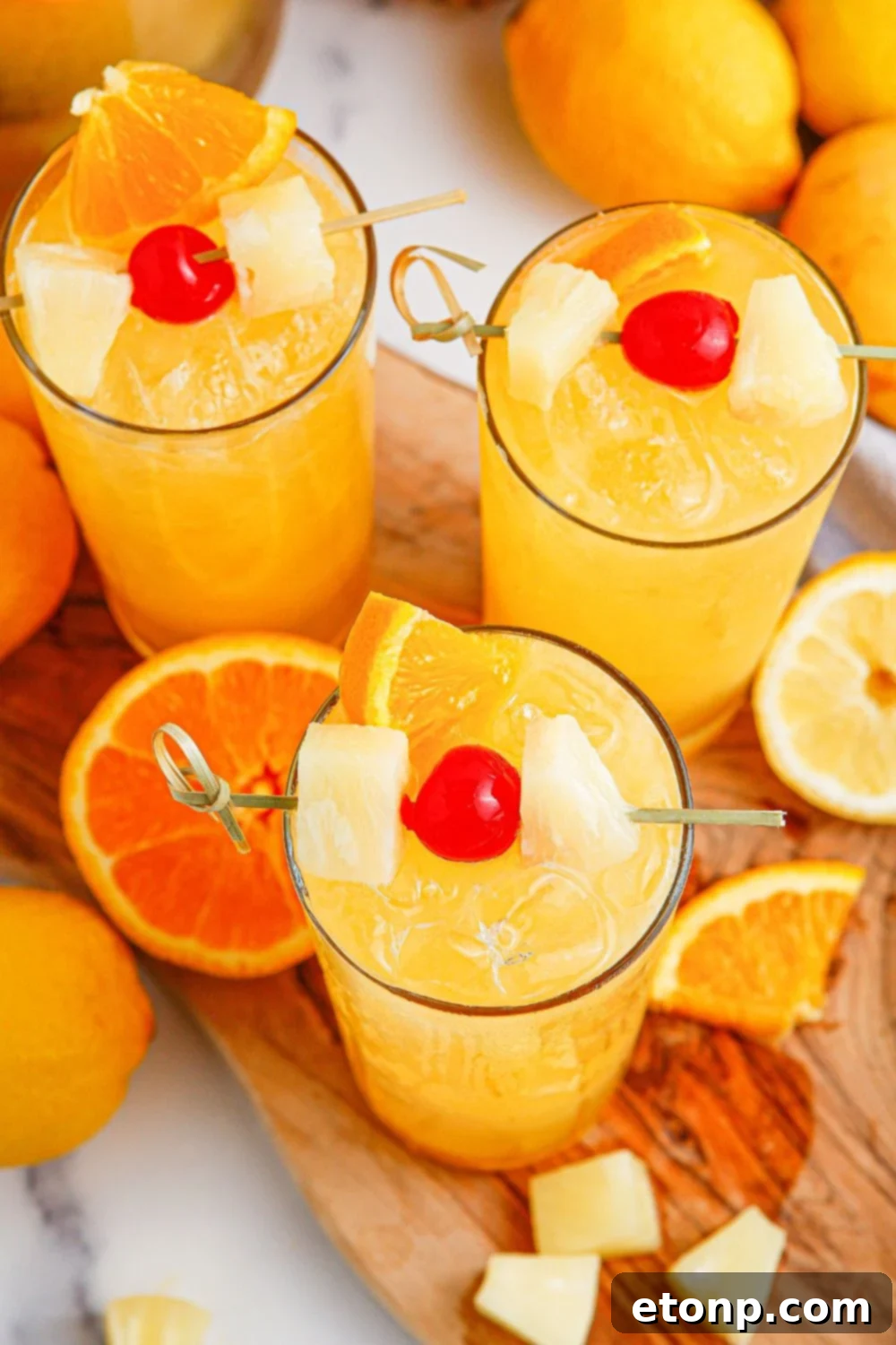 glasses with punch in them garnished with sliced fruit